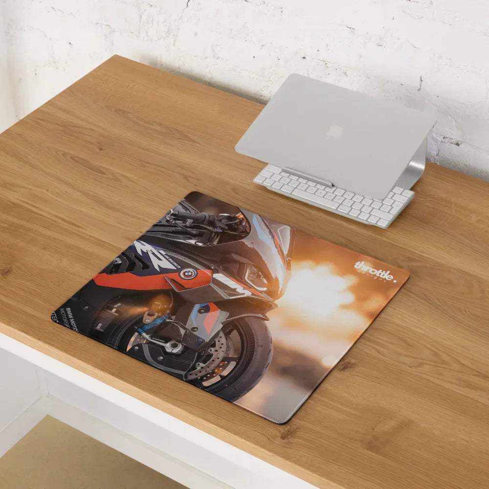 A large rectangular gaming mousepad featuring a black and orange bmw inspired m1000rr motorcycle with fiery exhaust and throttle branding