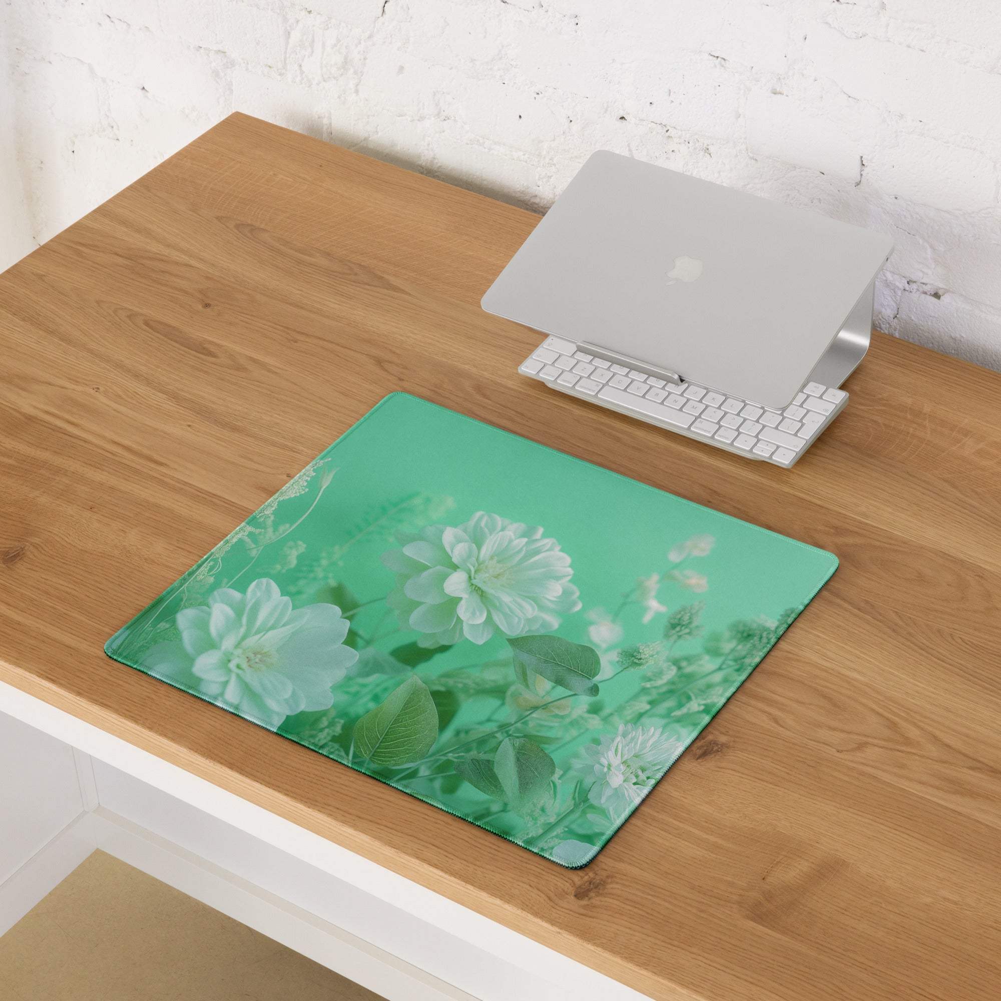 Floral green large gaming mousepad with white roses beside Apple laptop