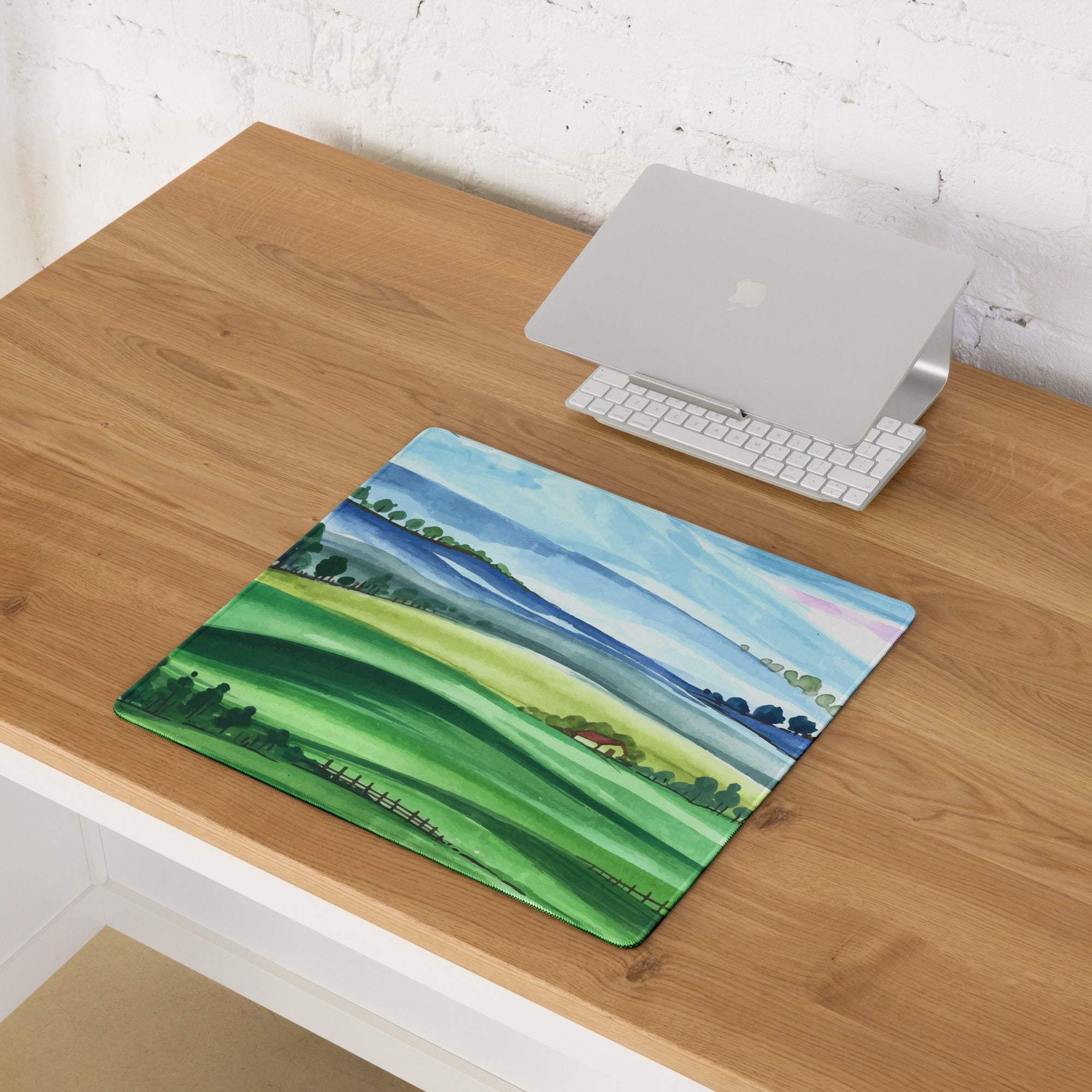 Large watercolor landscape gaming mouse pad with green hills, blue sky, non-slip stitched edges