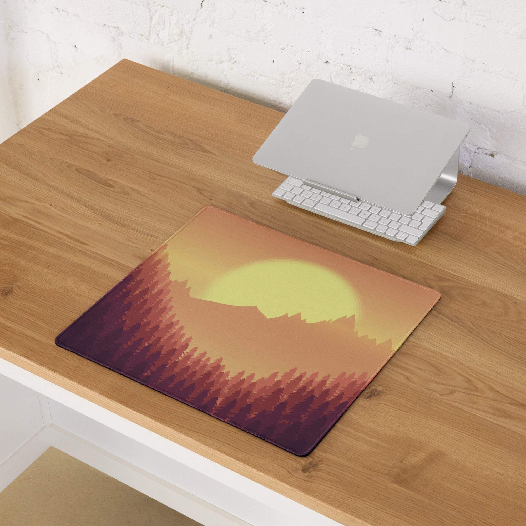 Epic Sunset Mountain Forest gaming mouse pad with vibrant sunset over silhouetted mountains on wooden desk