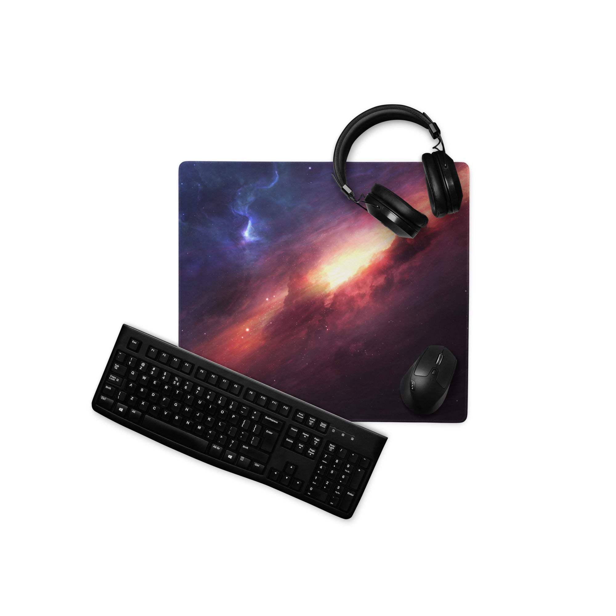 Black keyboard, mouse, and headphones on Cosmic Galaxy Nebula gaming mousepad