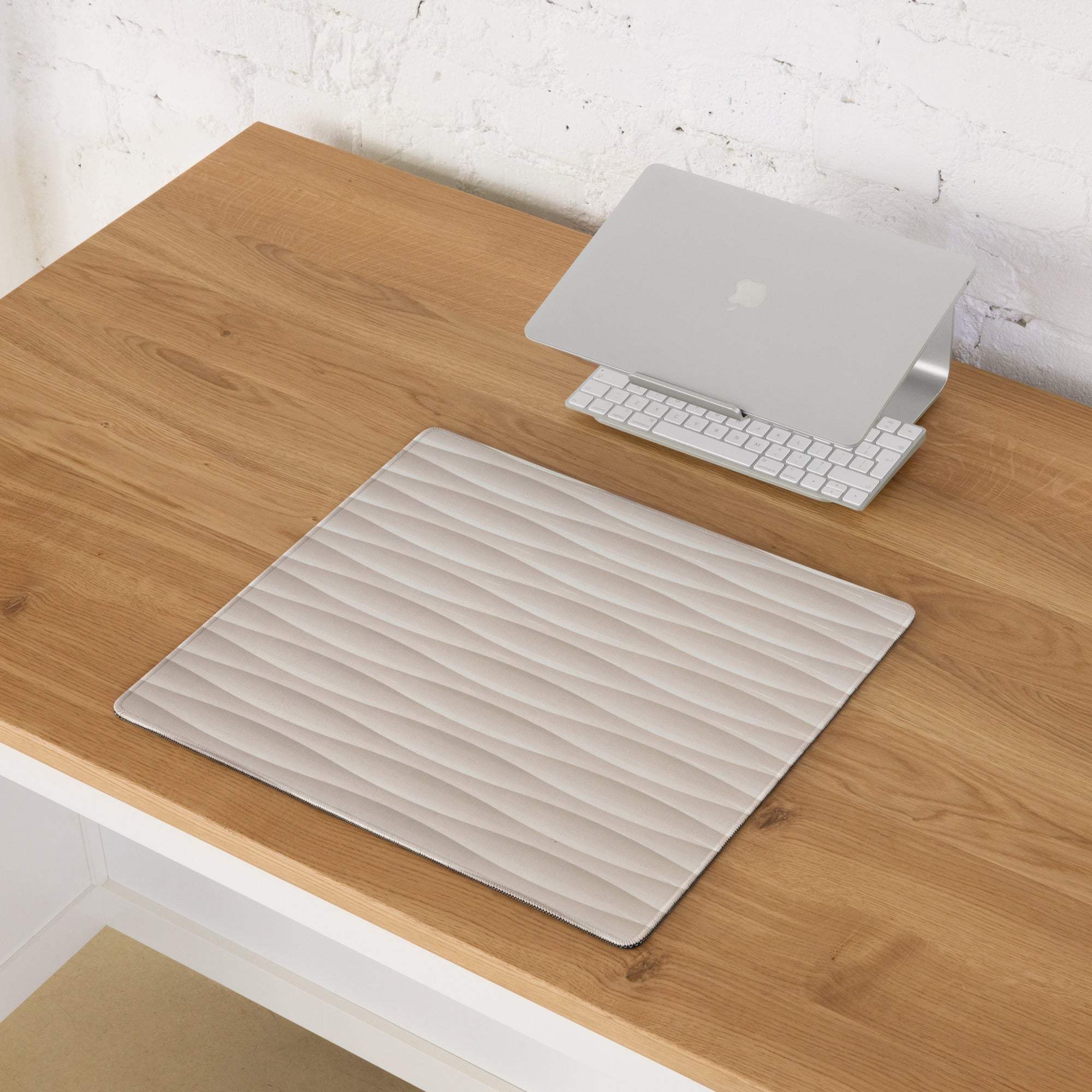 Silver laptop stand on cream beige wave textured gaming mouse pad
