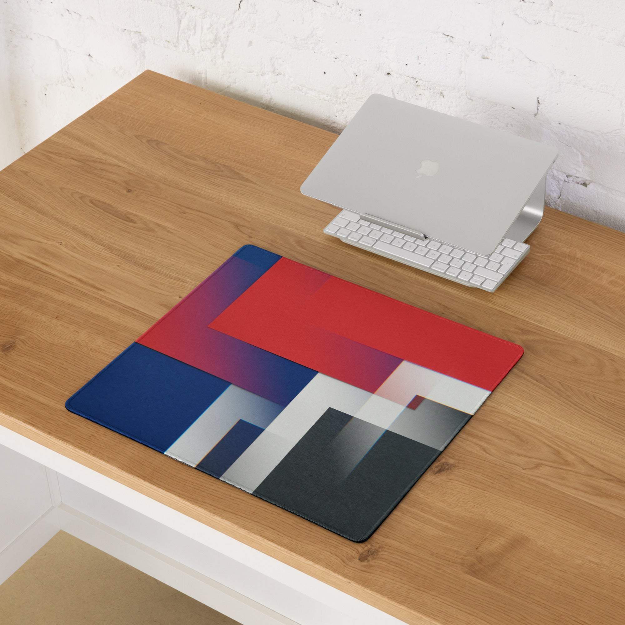 Geometric gaming mouse pad with bold red blue black gradients, non-slip backing