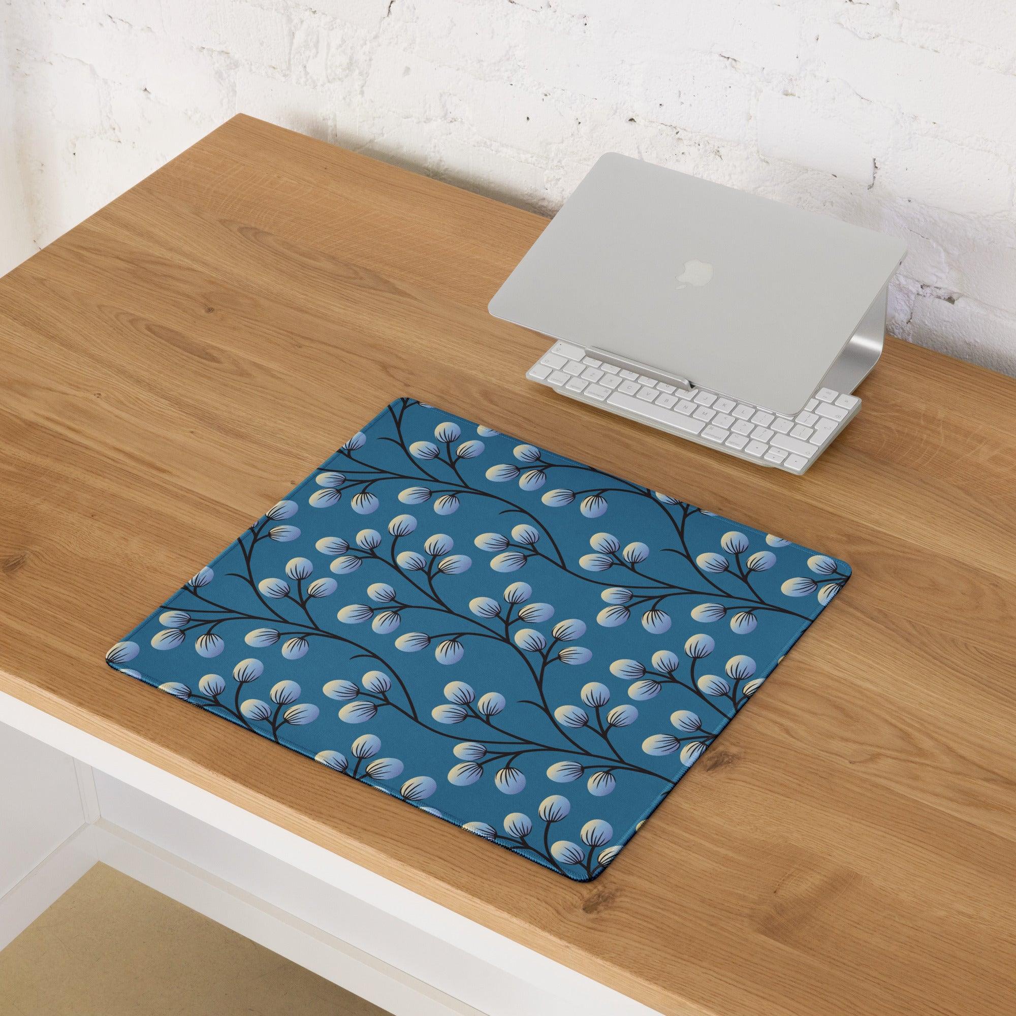 Elegant floral branches on deep blue gaming mouse pad with black branches and light blue buds