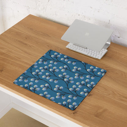 Elegant floral branches on deep blue gaming mouse pad with black branches and light blue buds