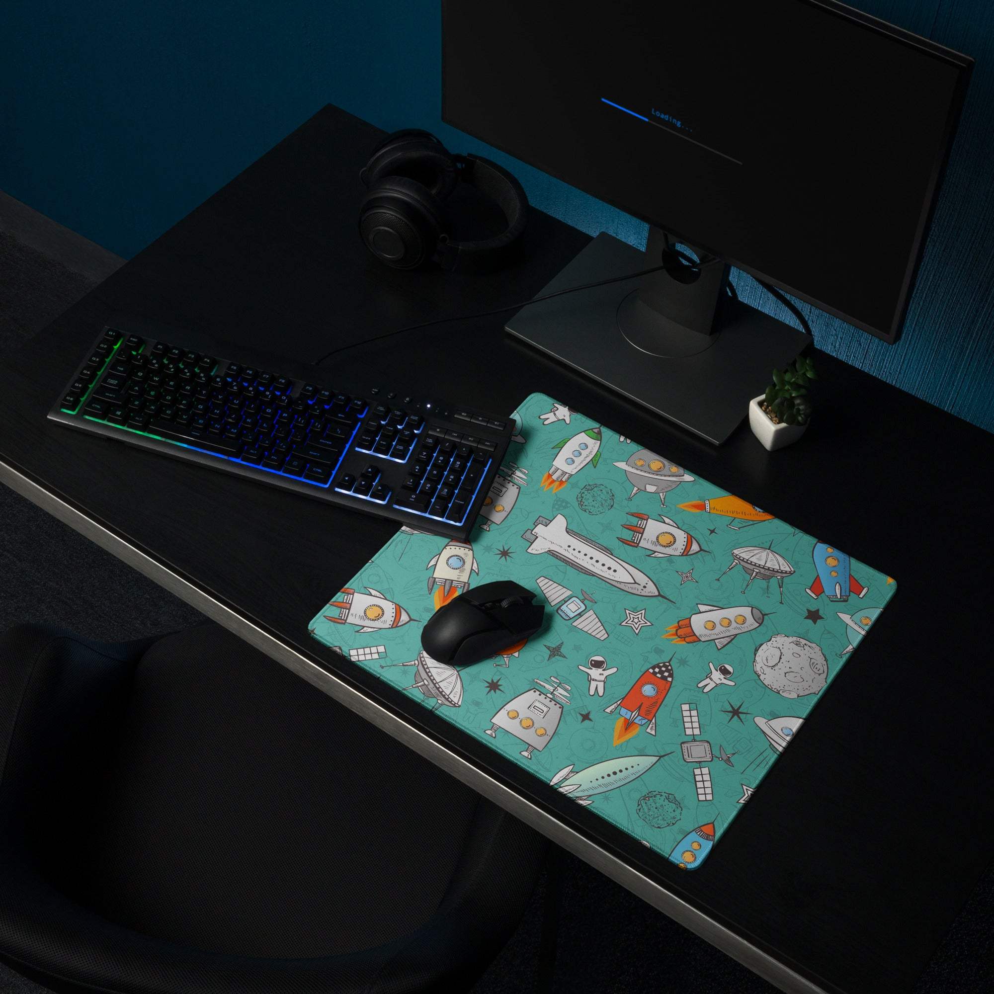 Teal space-themed gaming mouse pad with rockets, astronauts, planets, non-slip base