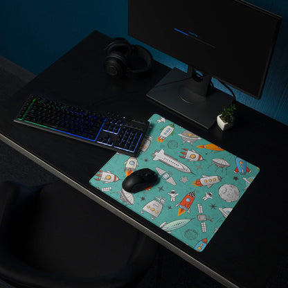 Teal space-themed gaming mouse pad with rockets, astronauts, planets, non-slip base