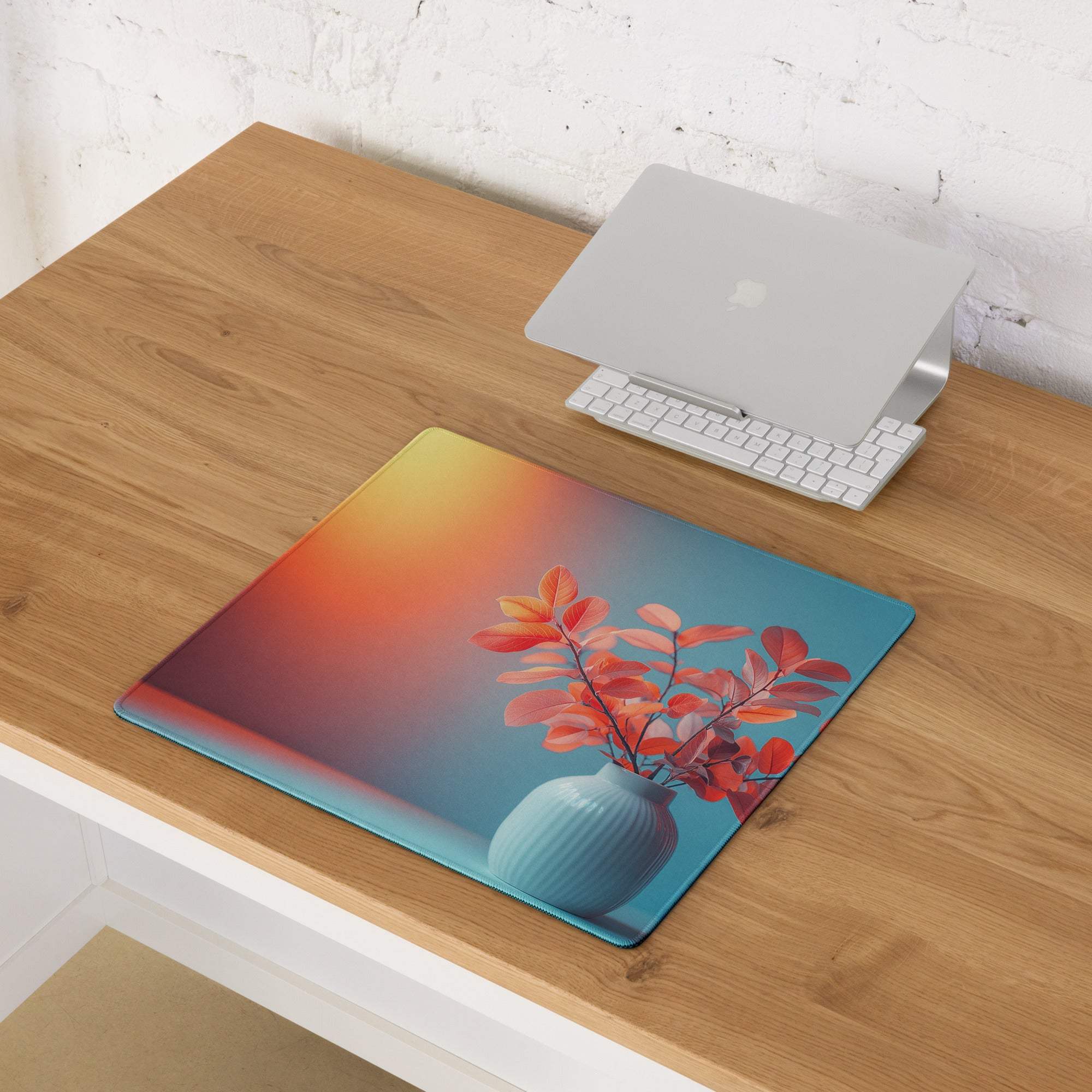 Vibrant gradient gaming mouse pad with orange-to-blue fade, red leaves vase