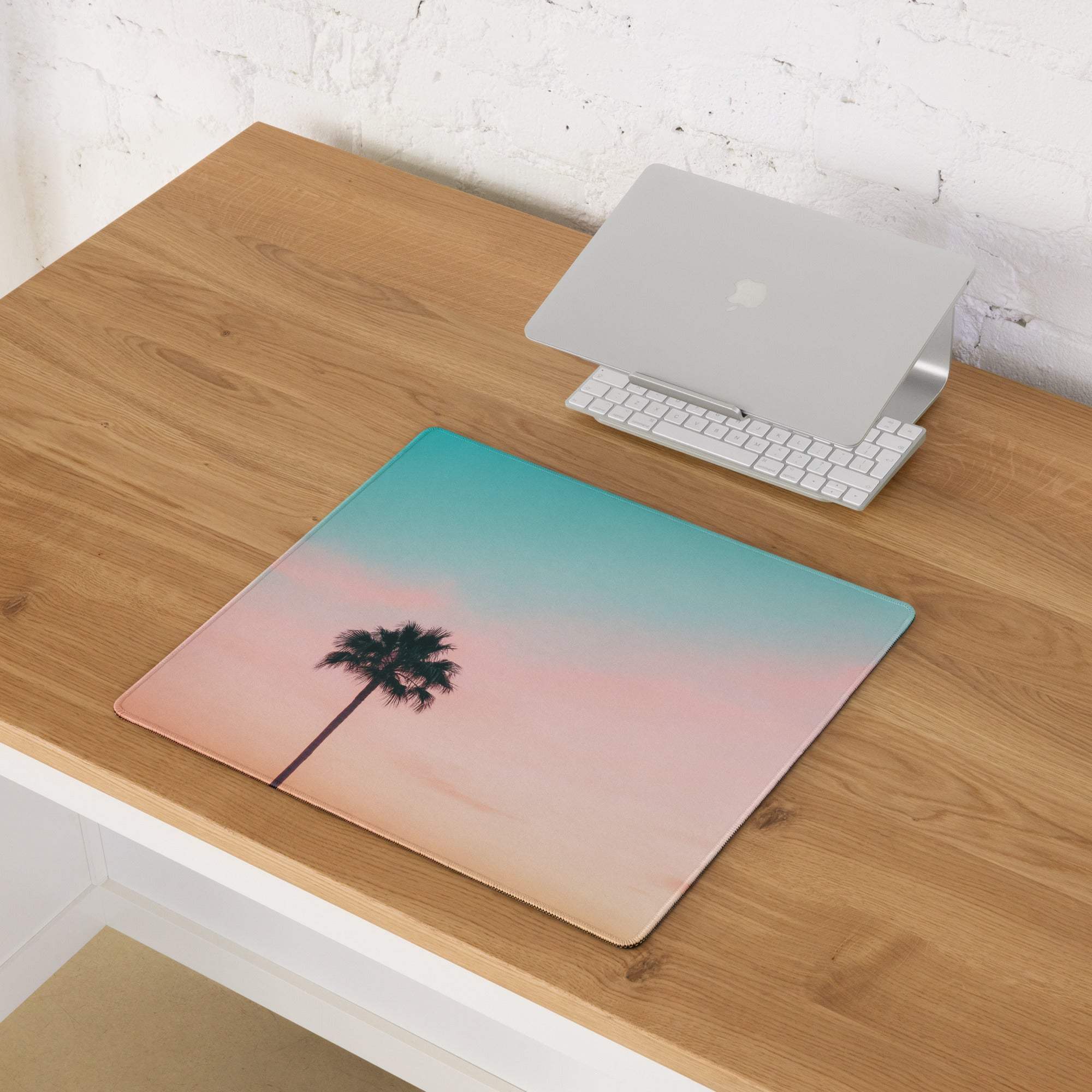 Large pastel sunset palm tree gaming mouse pad with teal-to-pink gradient sky and non-slip desk mat design