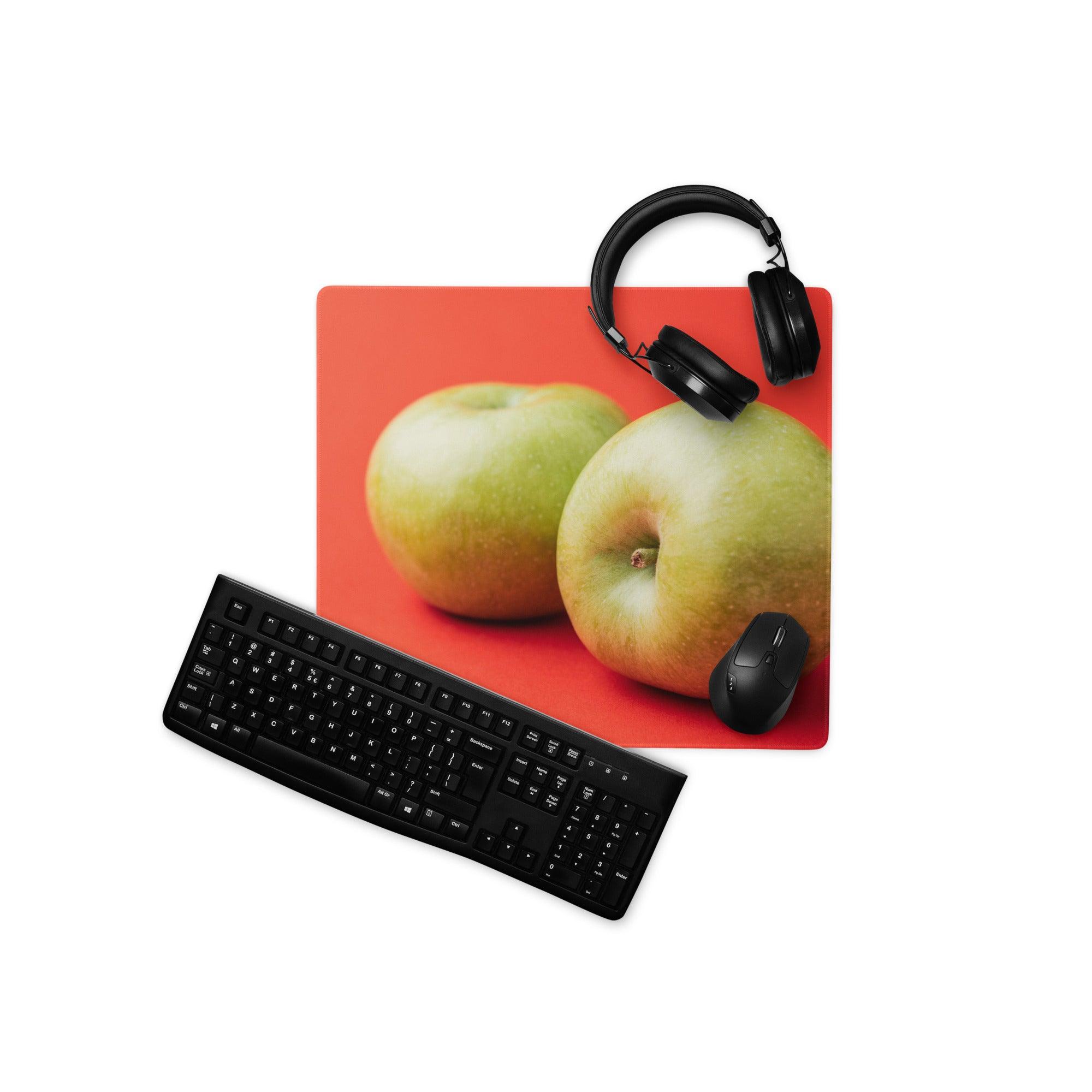 Red rectangular mousepad with vibrant green apple duo on orange background