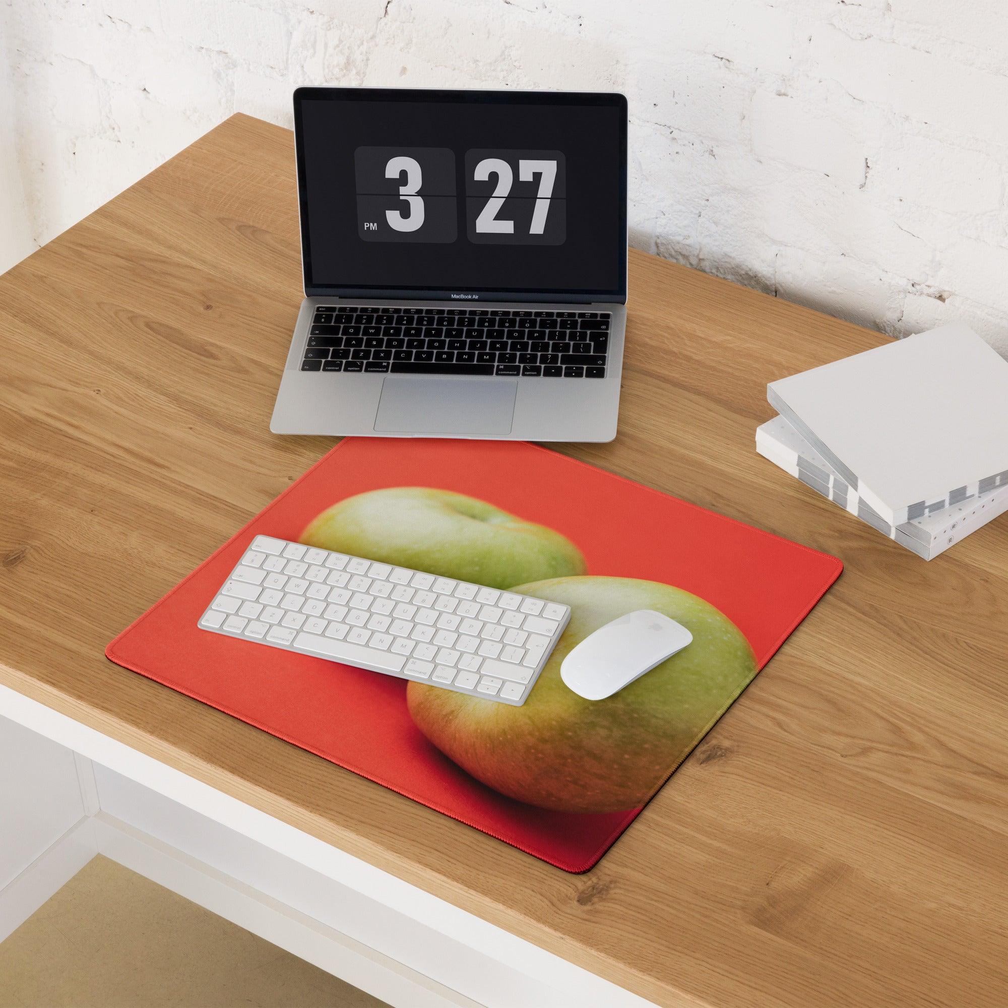 Red gaming mousepad with vibrant green apple duo on orange background