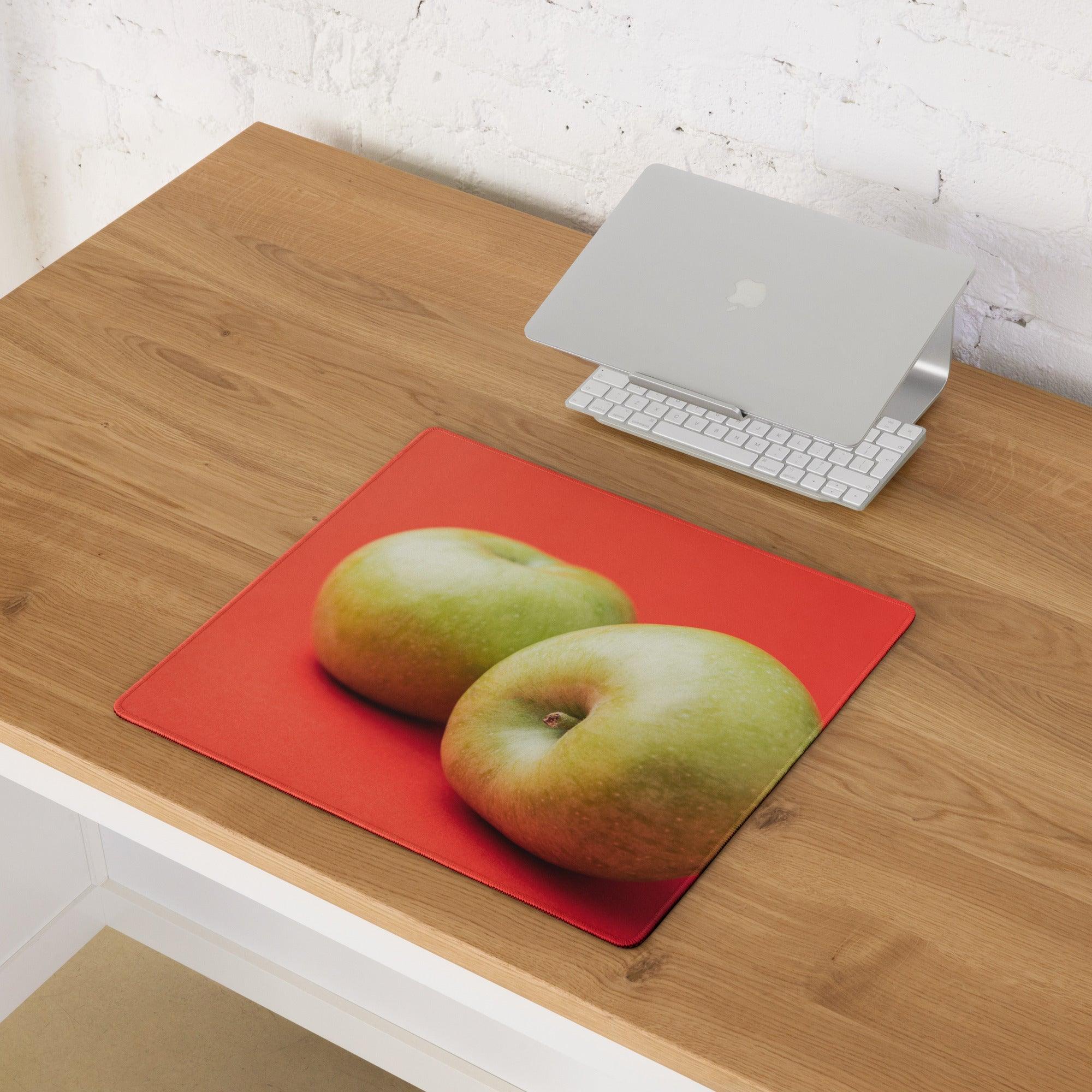Red rectangular gaming mousepad with two green apples on vibrant red background
