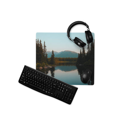 Black keyboard and mouse on serene forest lake gaming mouse pad