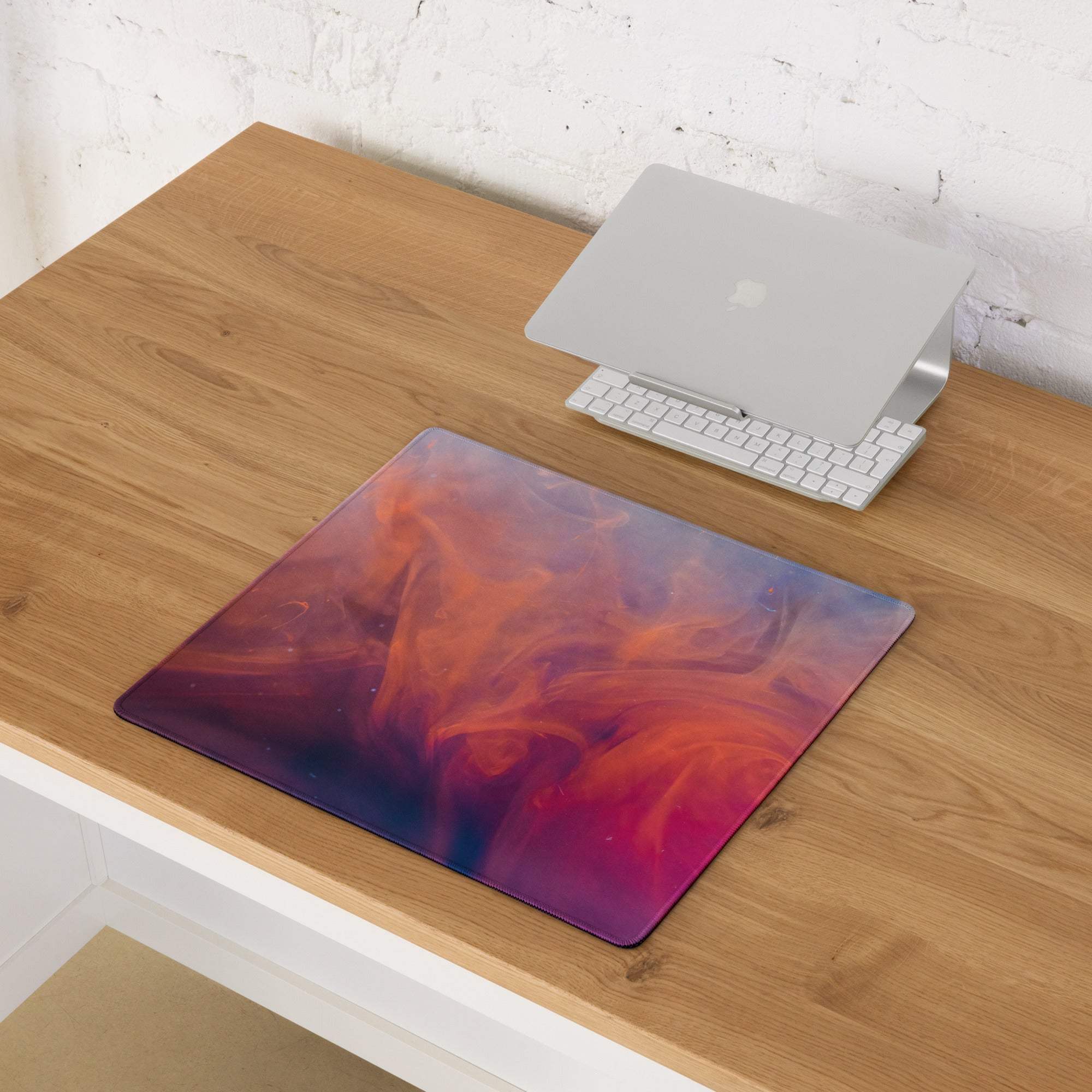 Large gaming mouse pad with vibrant orange pink purple nebula gradient and non-slip base