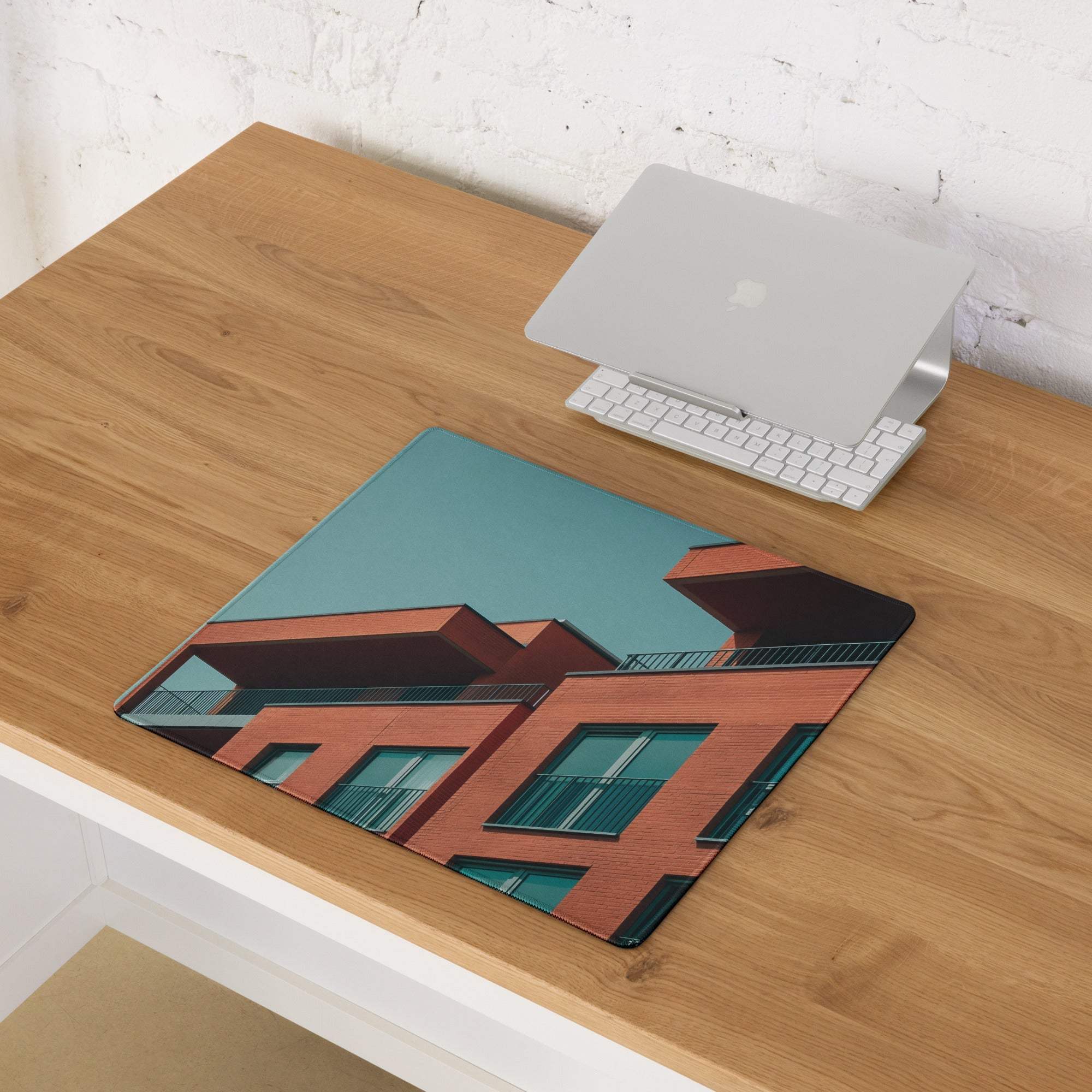 Sleek large edge-stitched gaming mouse pad with red brick buildings and teal sky