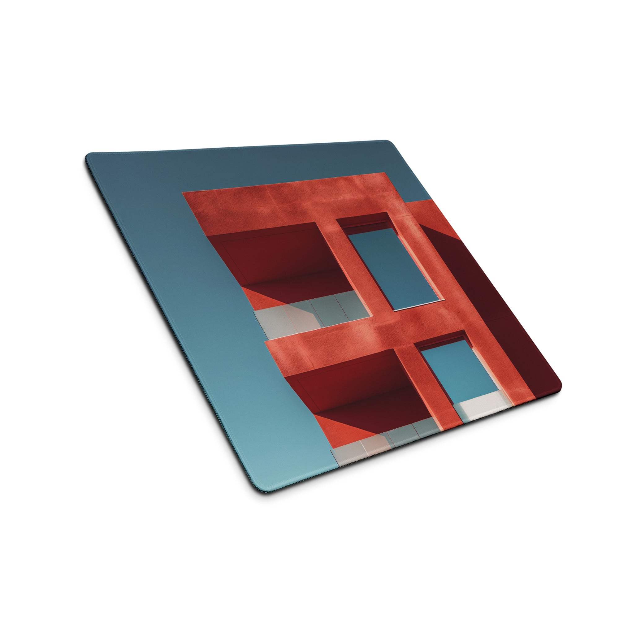 Large architectural gaming mouse pad with red teal geometric shapes, edge stitching, non-slip base