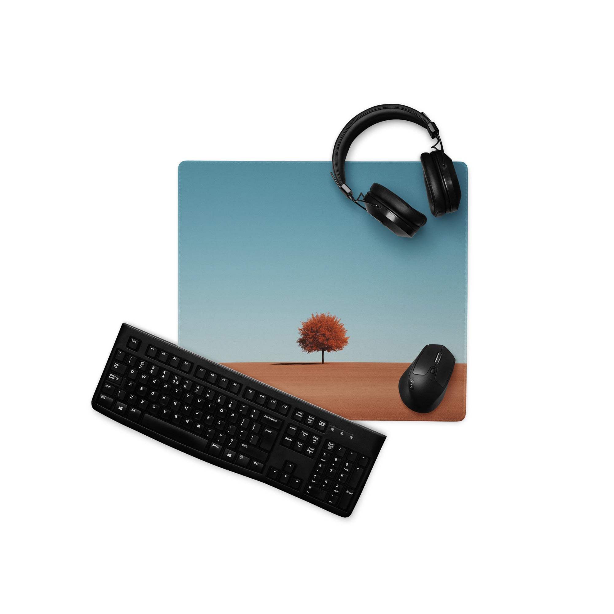 Minimalist desert landscape gaming mouse pad with red leaf tree, blue sky, headphones, keyboard