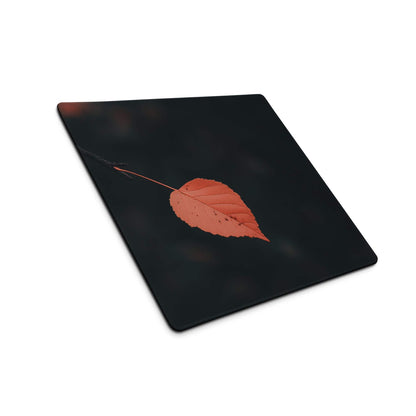 Black rectangular cutting board with orange leaf design on gaming mouse pad
