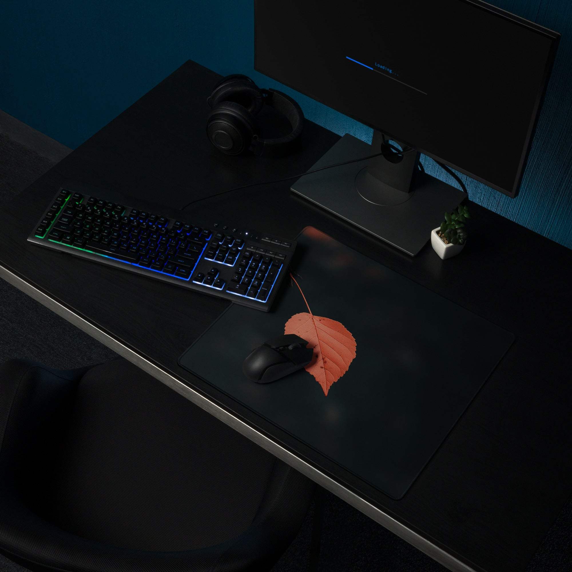 Black minimalist leaf gaming mouse pad with orange leaf design, non-slip base, stitched edges