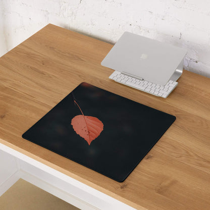 Black minimalist leaf gaming mouse pad with orange leaf design, non-slip base, stitched edges