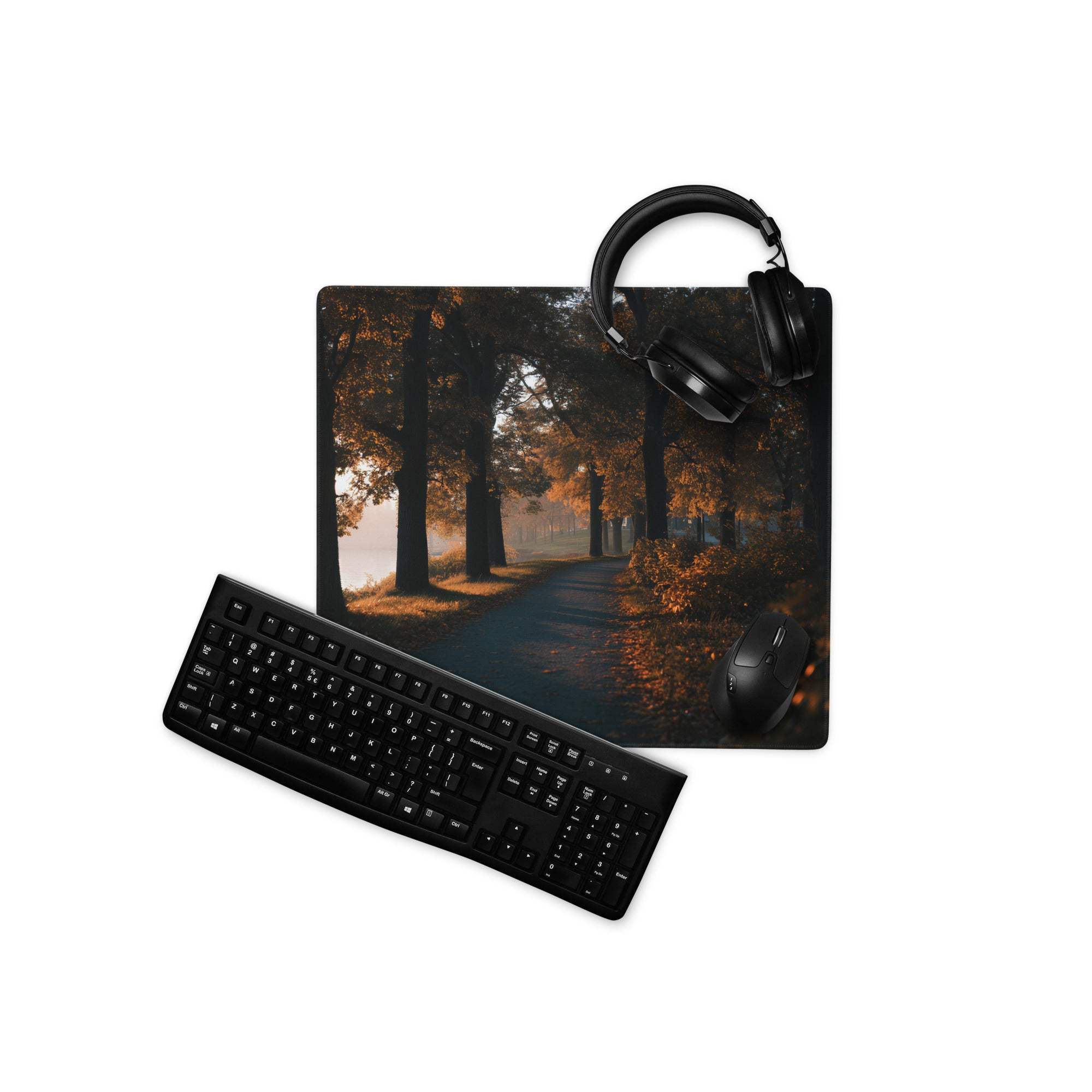 Black matte qwerty keyboard on autumn forest path gaming mouse pad