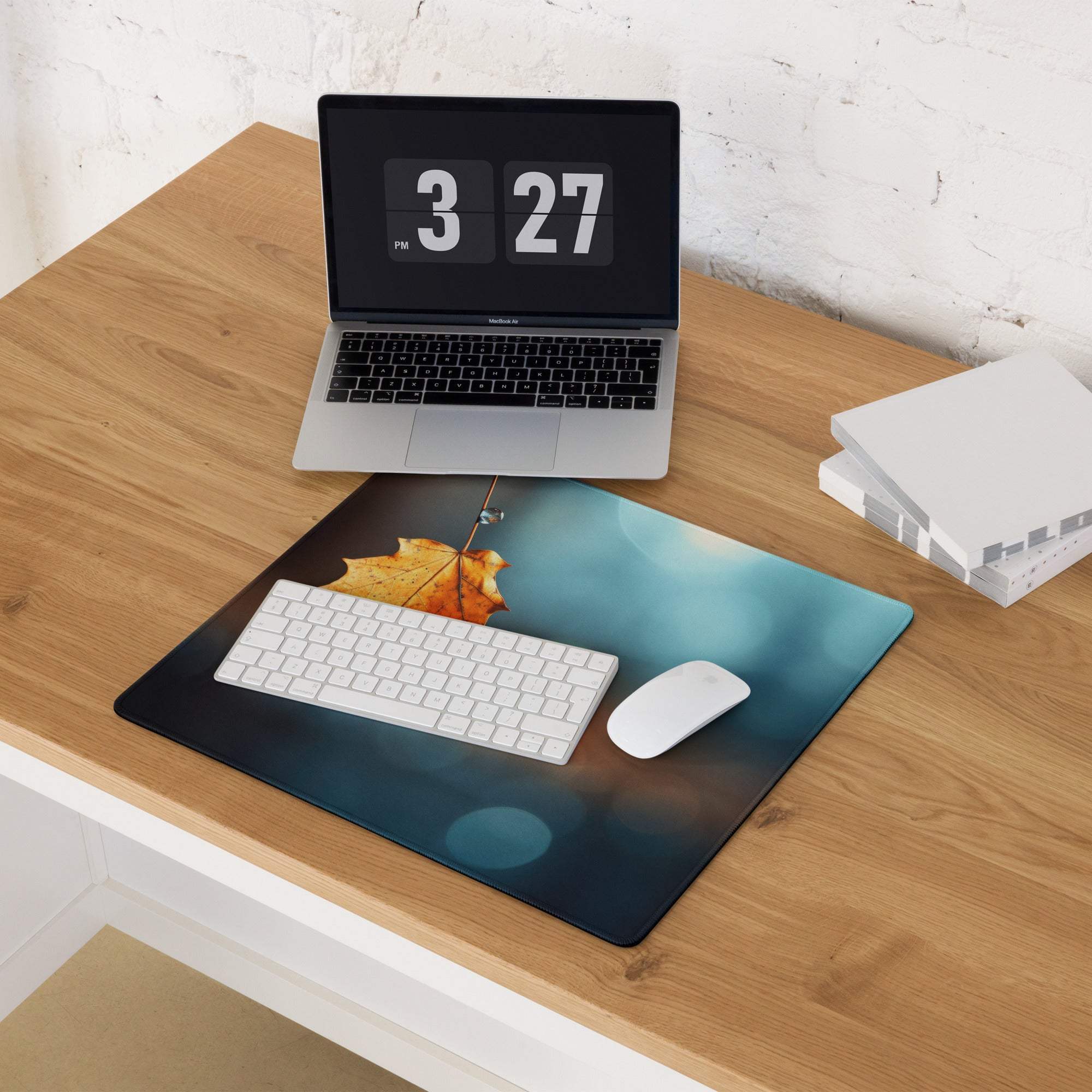 Autumn leaf gaming mouse pad with orange maple leaf on water, blue bokeh, under white keyboard
