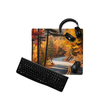 Black matte QWERTY keyboard on vibrant autumn forest gaming mouse pad