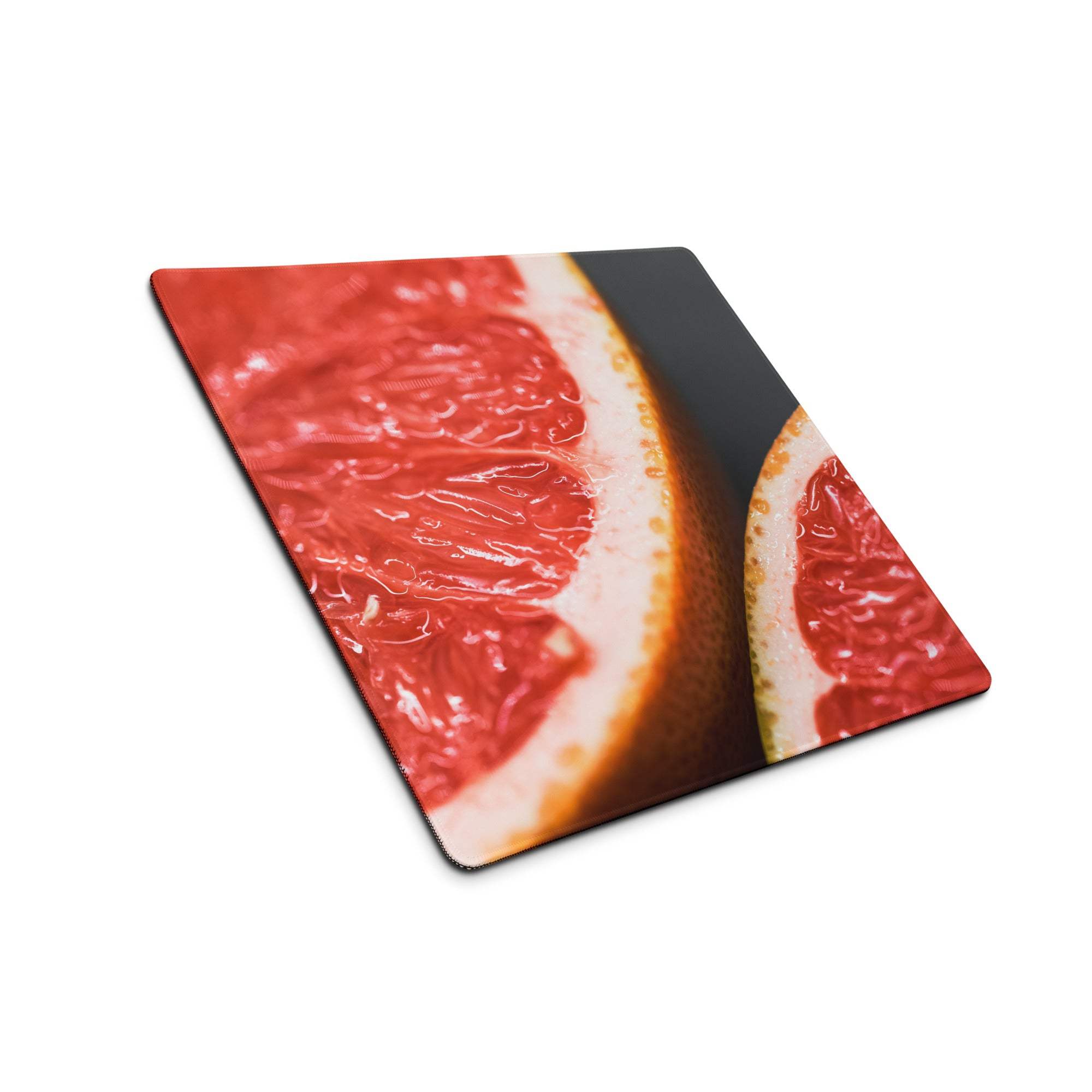 Vibrant red grapefruit slice on sleek square glass gaming mousepad