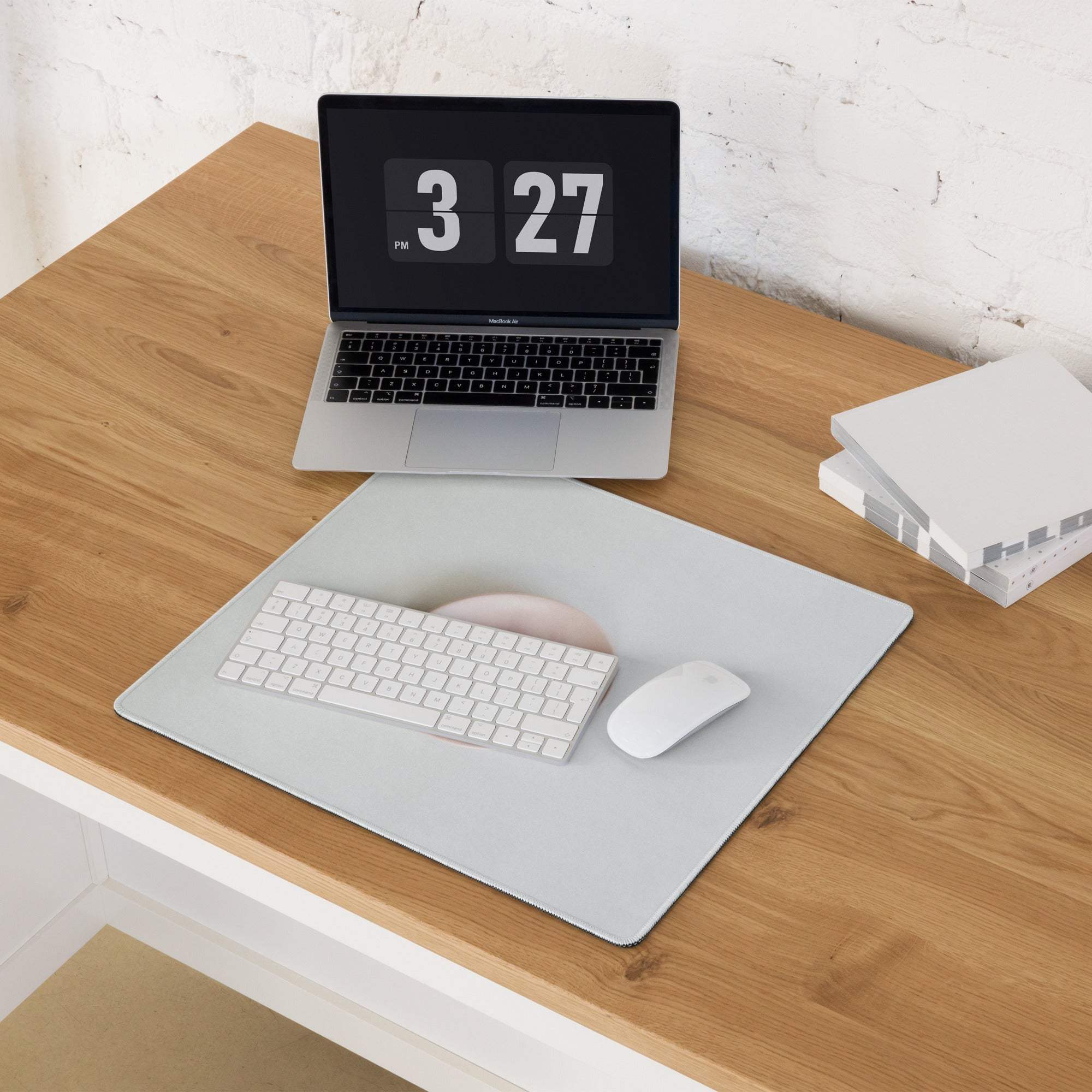 Silver MacBook on sleek minimalist large gaming mouse pad, 3:27 pm screen