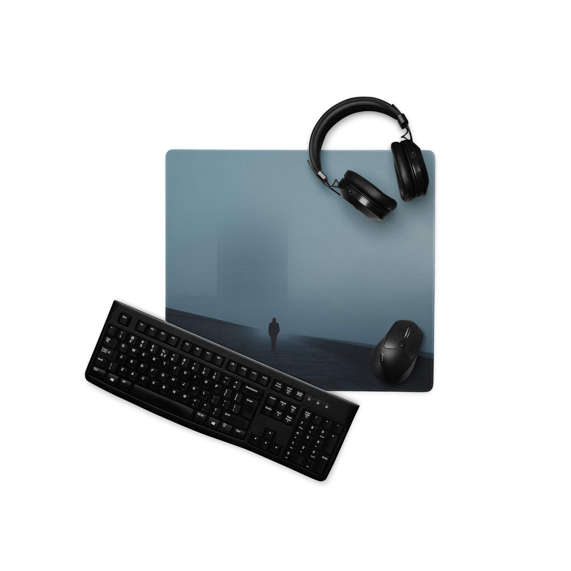 Black keyboard and mouse on Moody Blue Mist gaming mousepad with lone figure