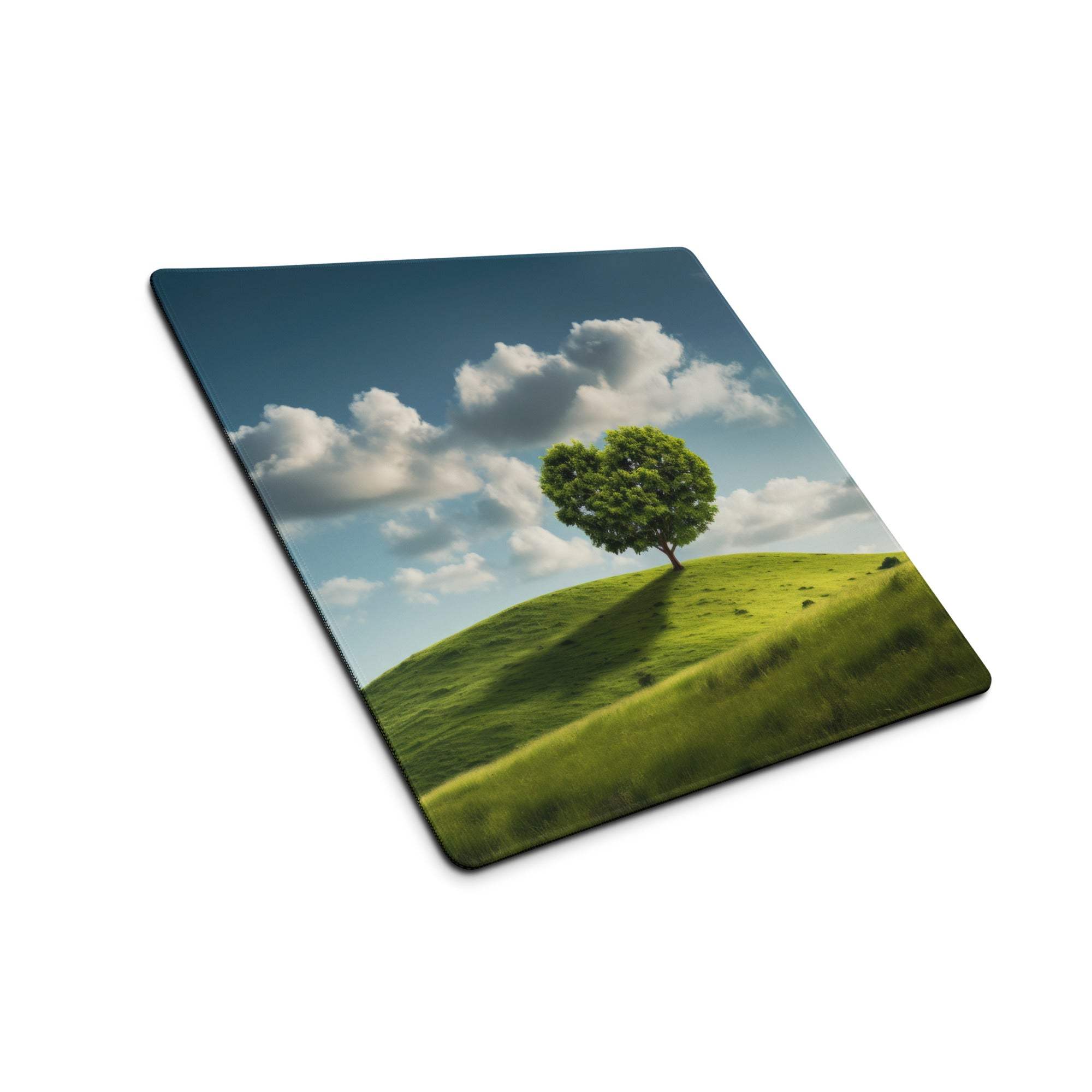Vibrant green tree on hill gaming mouse pad, calm blue sky atmosphere