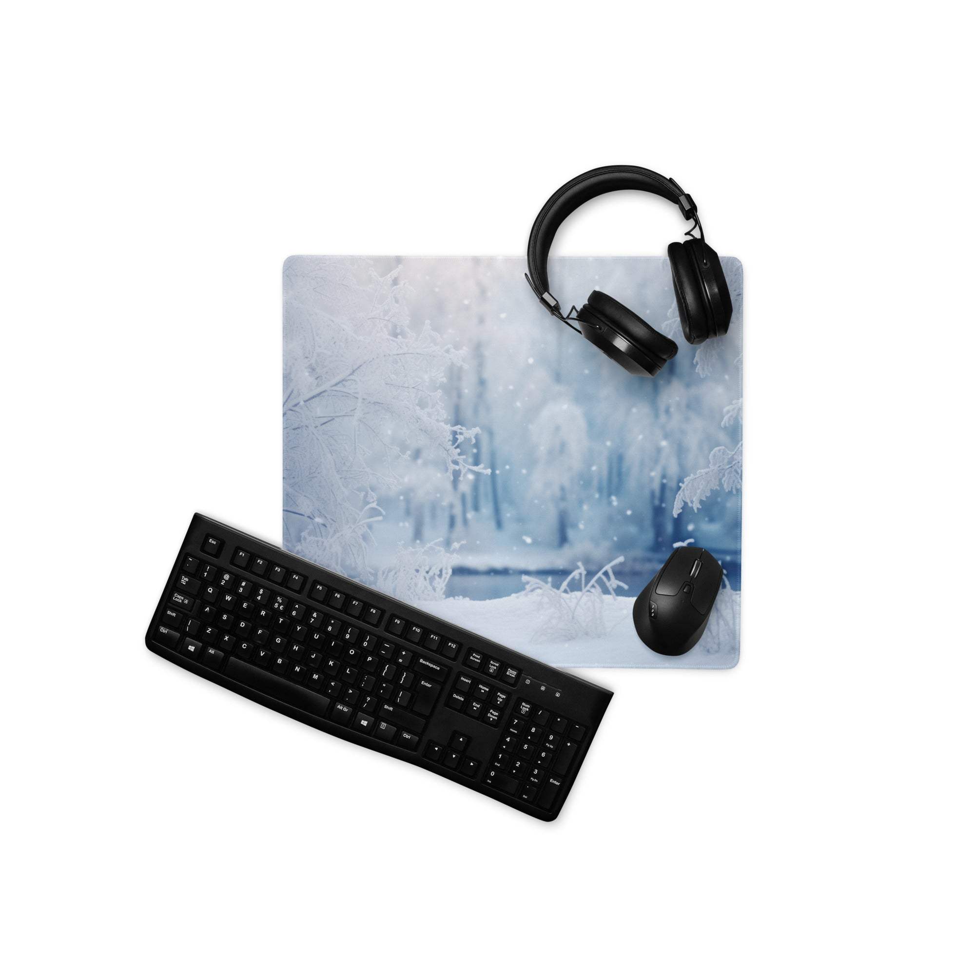 Black keyboard, mouse, and headphones on frosty winter forest gaming mouse pad