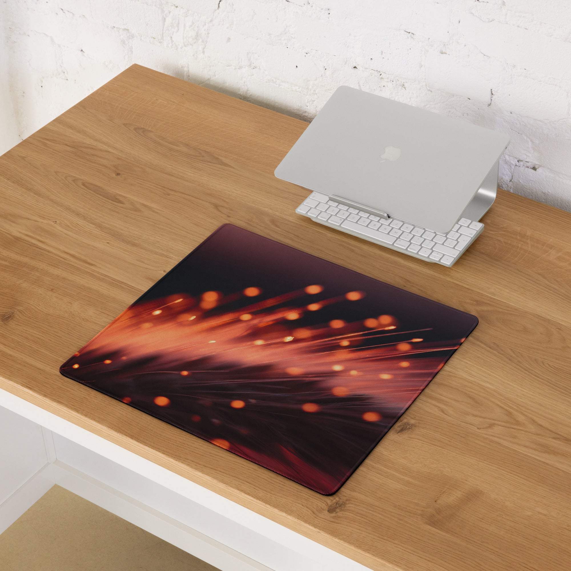 Dynamic Neon Ember Glow large esports gaming mouse pad on wooden desk with Apple laptop