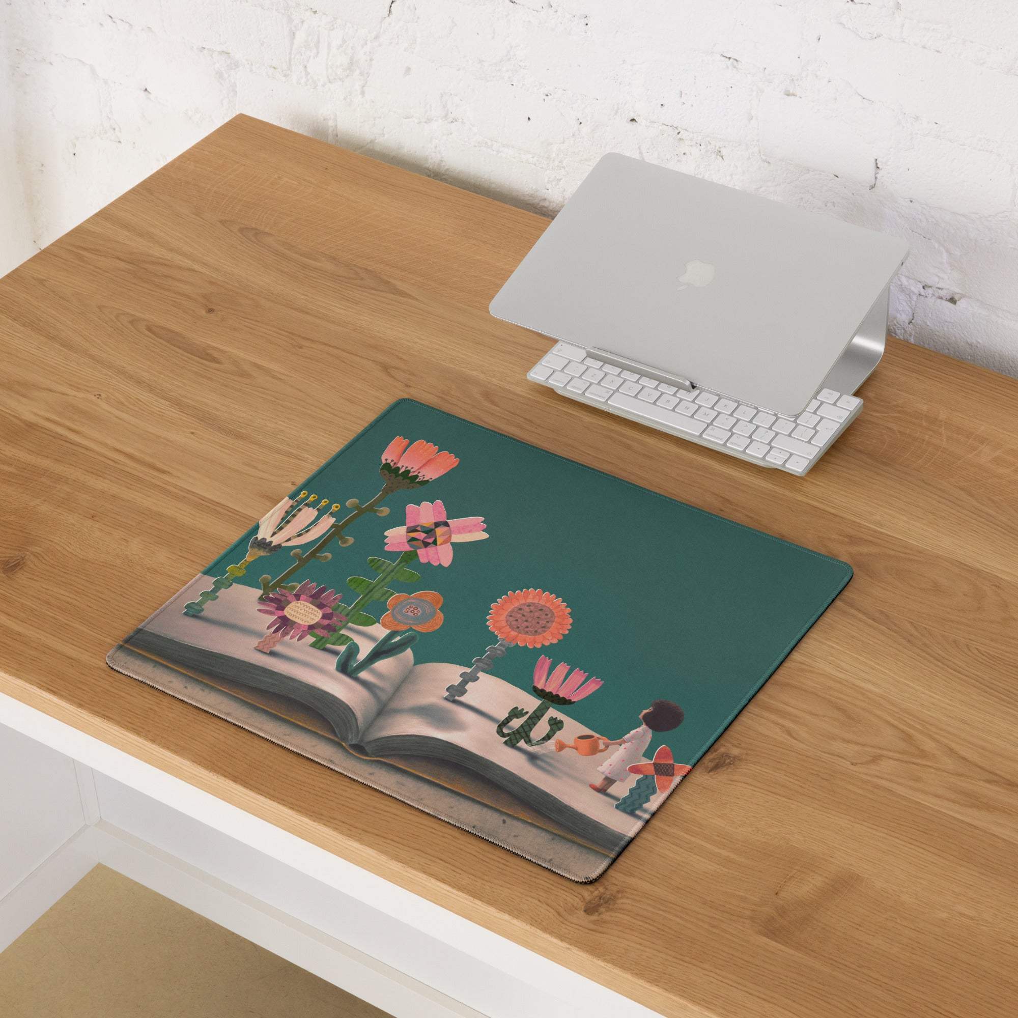 Teal pink floral desk pad featuring colorful flowers growing from an open book illustration for modern decor