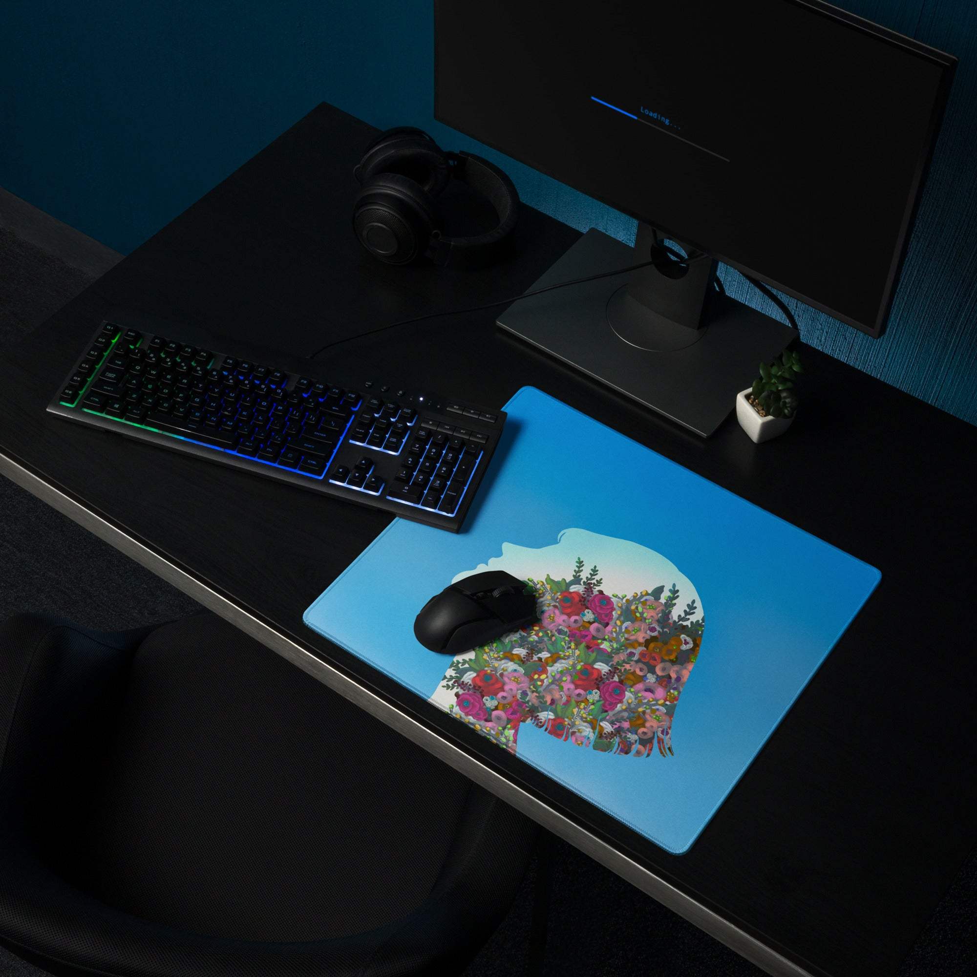 Blue mousepad with a vibrant floral design shaped like a human head silhouette for a colorful desk accessory