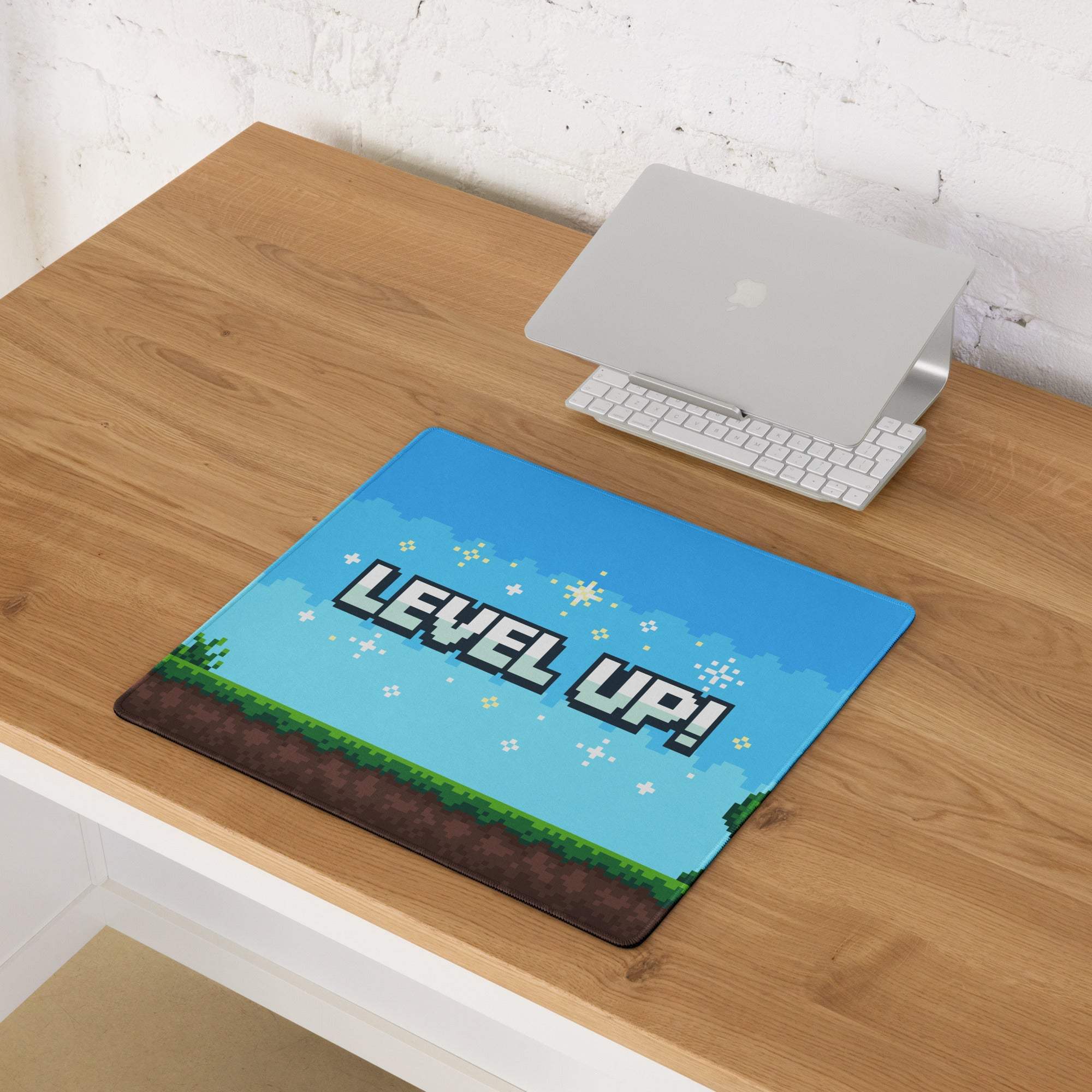 Level up pixel arcade mouse pad with blue pixelated design and green grass brown dirt border for gaming desk use