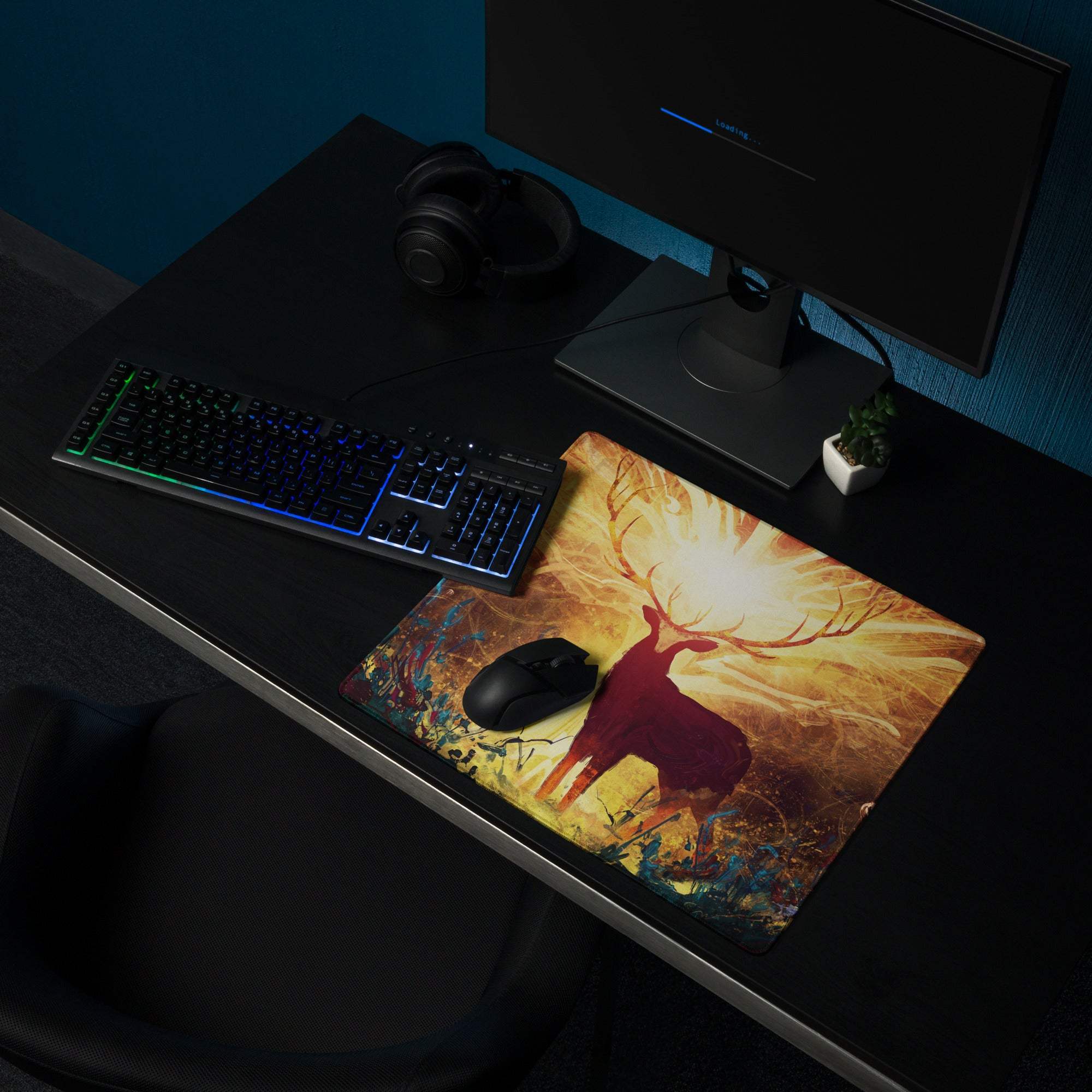 A rectangular gaming mousepad with a glowing red deer silhouette on a warm orange and gold digital art background