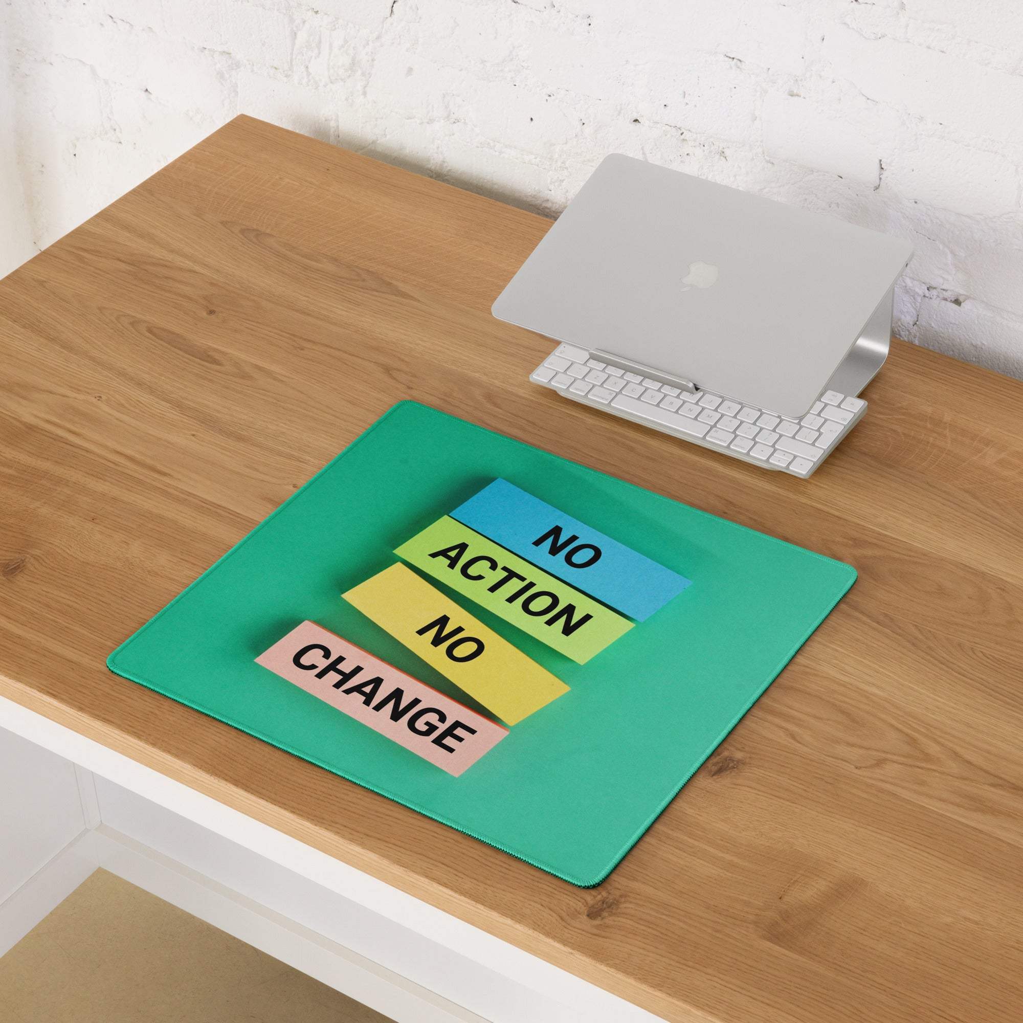Green motivational desk mouse pad with layered sticky-note design and no action no change text in black on multicolor strips