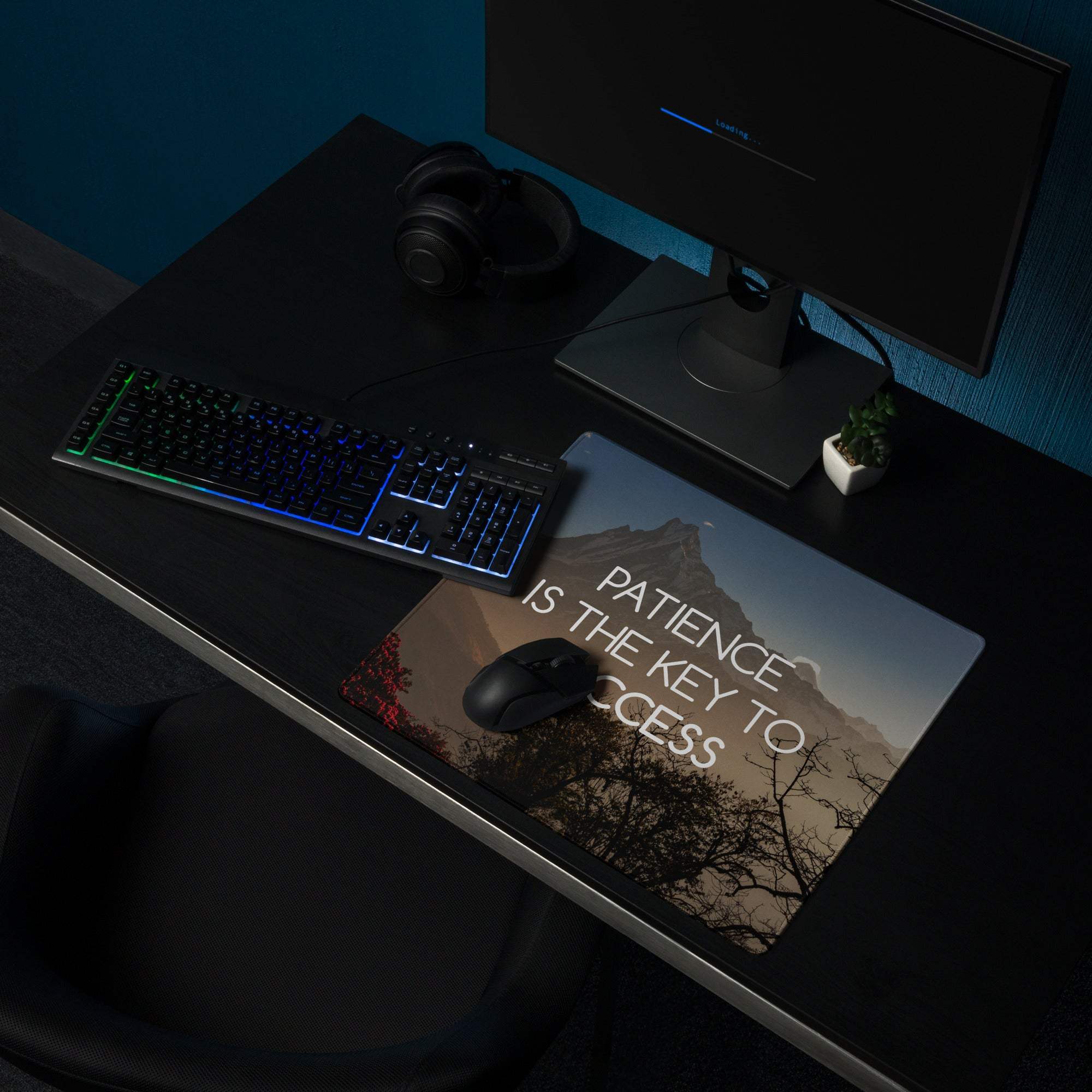 Rectangular blue mountain sunset landscape mouse pad with patience is the key to success text and black computer mouse on top