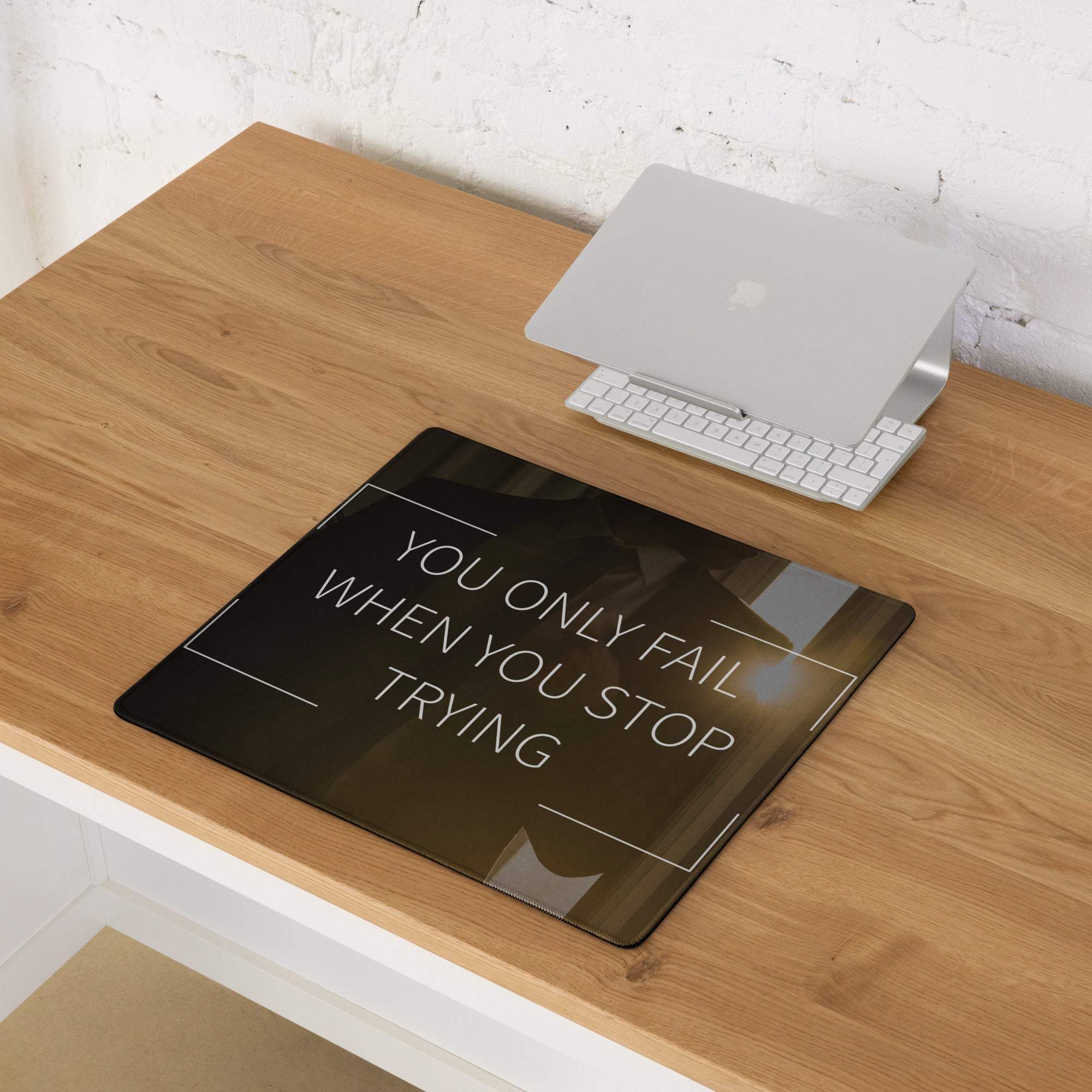 Black glass gaming mouse pad with white motivational text and thin white border for minimalist esports desk setup