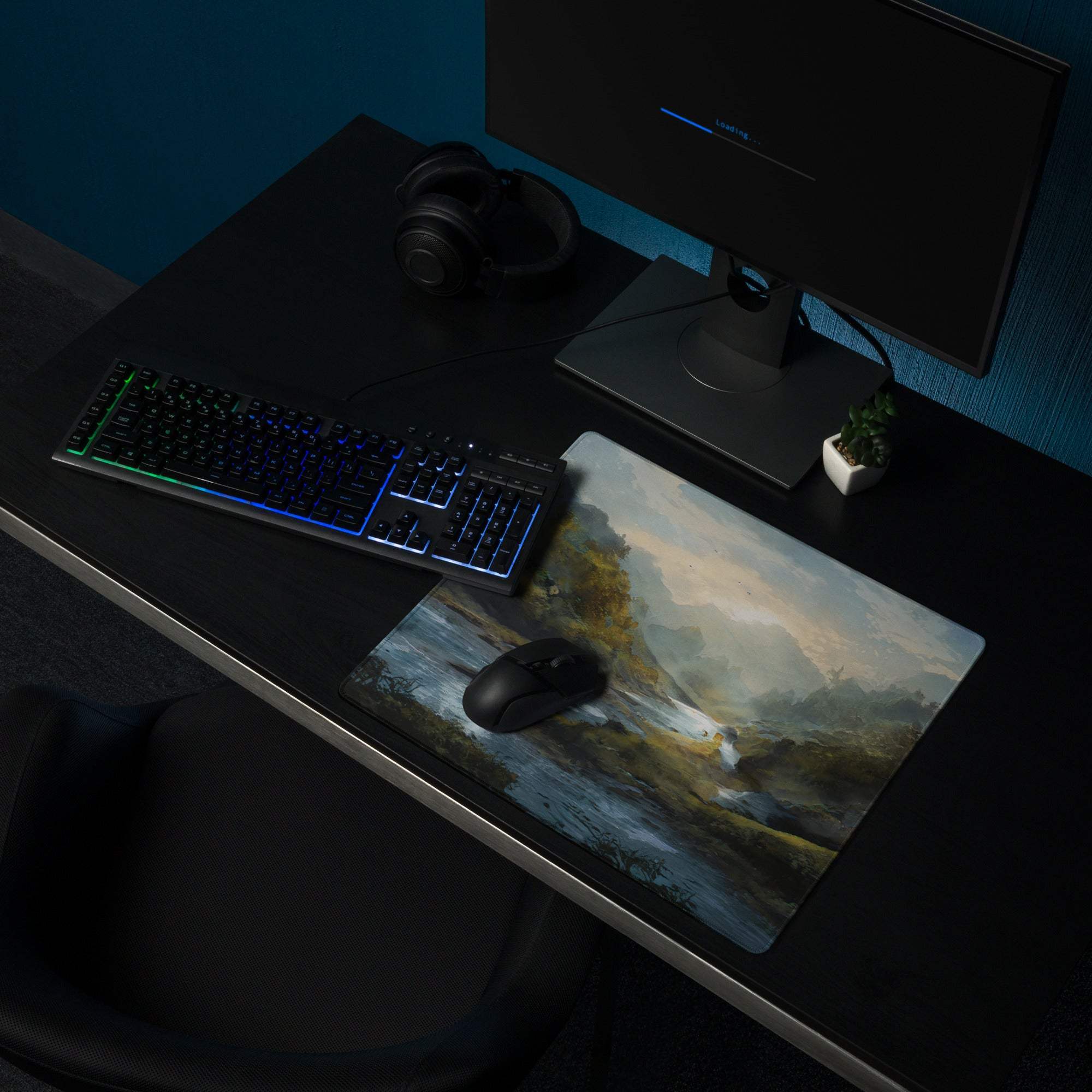 A rectangular gaming mousepad with a painterly landscape design in muted blues green and earthy tones for desktop use