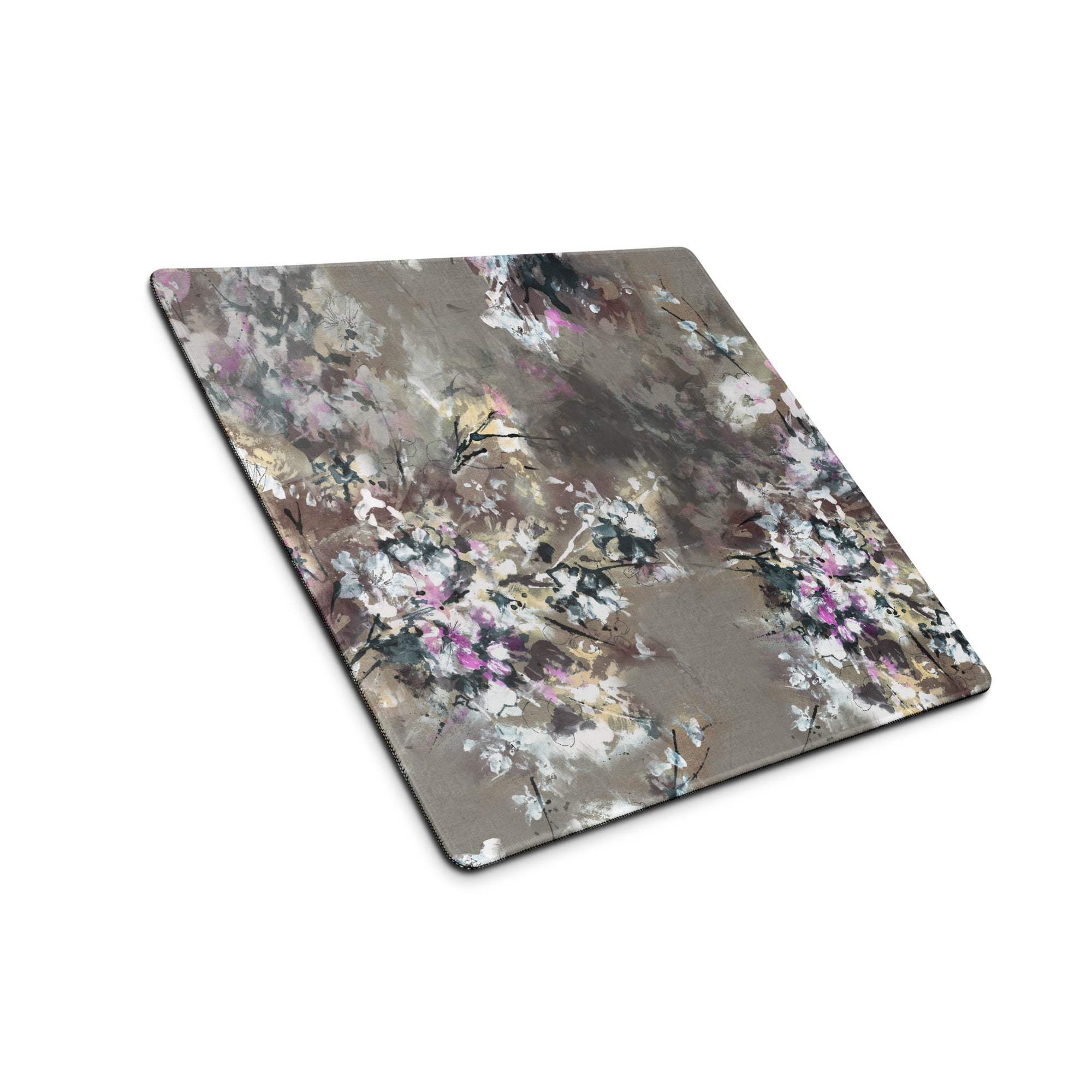 A rectangular floral abstract gaming mouse pad with soft pink white and gray tones on a textured surface