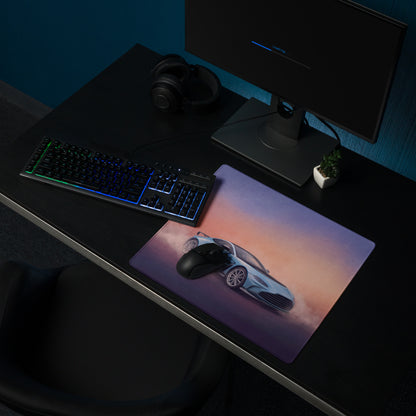 A rectangular non-slip pc mousepad featuring a light blue aston martin vantage gt3 against a sunset sky gradient