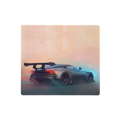 A gunmetal apex desk pad featuring a sleek dark gray aston martin vulcan sports car with rear spoiler and glowing taillights