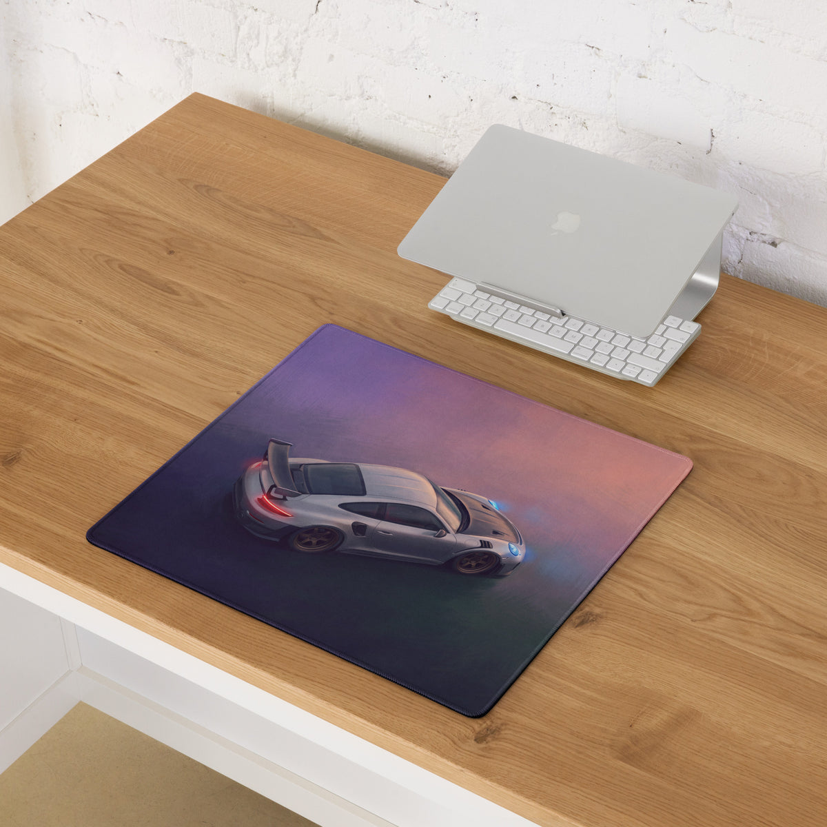 Porsche 911 gt3 rs inspired aerial edition desk mat featuring a silver porsche on a purple to pink gradient background