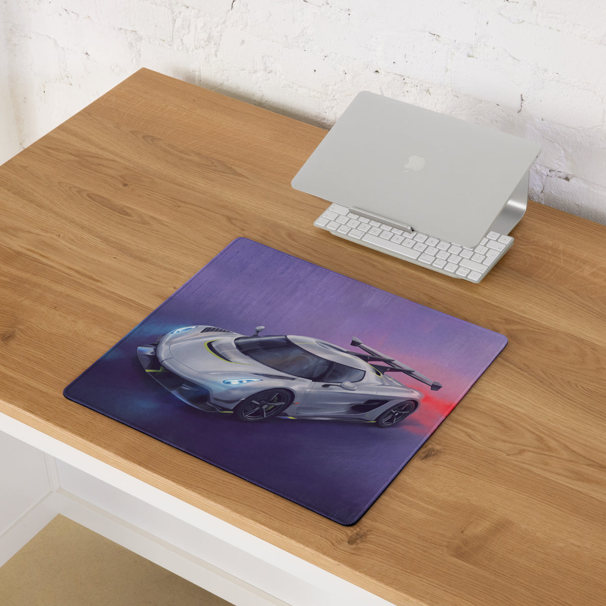 Koenigsegg jesko inspired silver apex desk pad with silver koenigsegg hypercar graphic on purple and red gradient background
