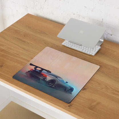 Rectangular gunmetal apex desk pad with stitched edge featuring dark gray aston martin vulcan car and glowing underglow design