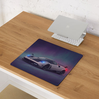 Rectangular silver carbon desk pad featuring a white pagani huayra with blue and red light accents on purple background