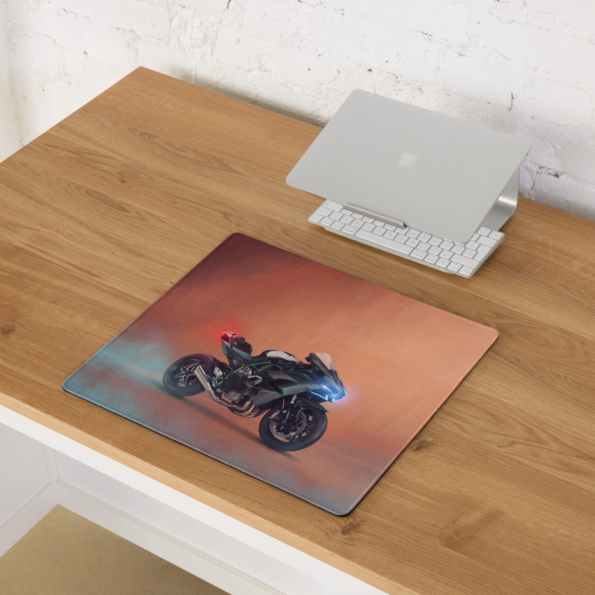 Rectangular Kawasaki Ninja H2 inspired extra large desk pad with black green motorcycle and glowing blue headlights on orange teal gradient background