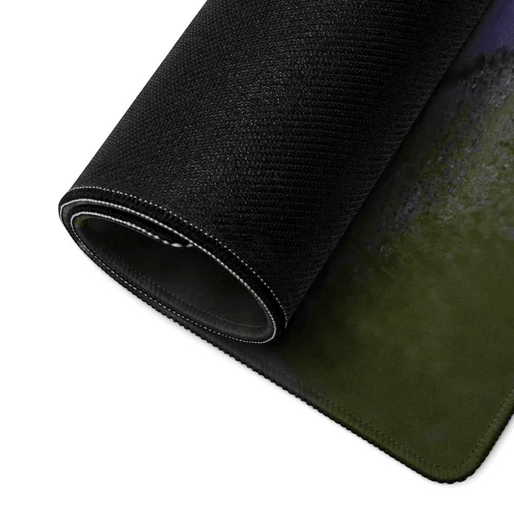 Rolled black gaming mouse pad with textured surface and stitched edges on dark background.
